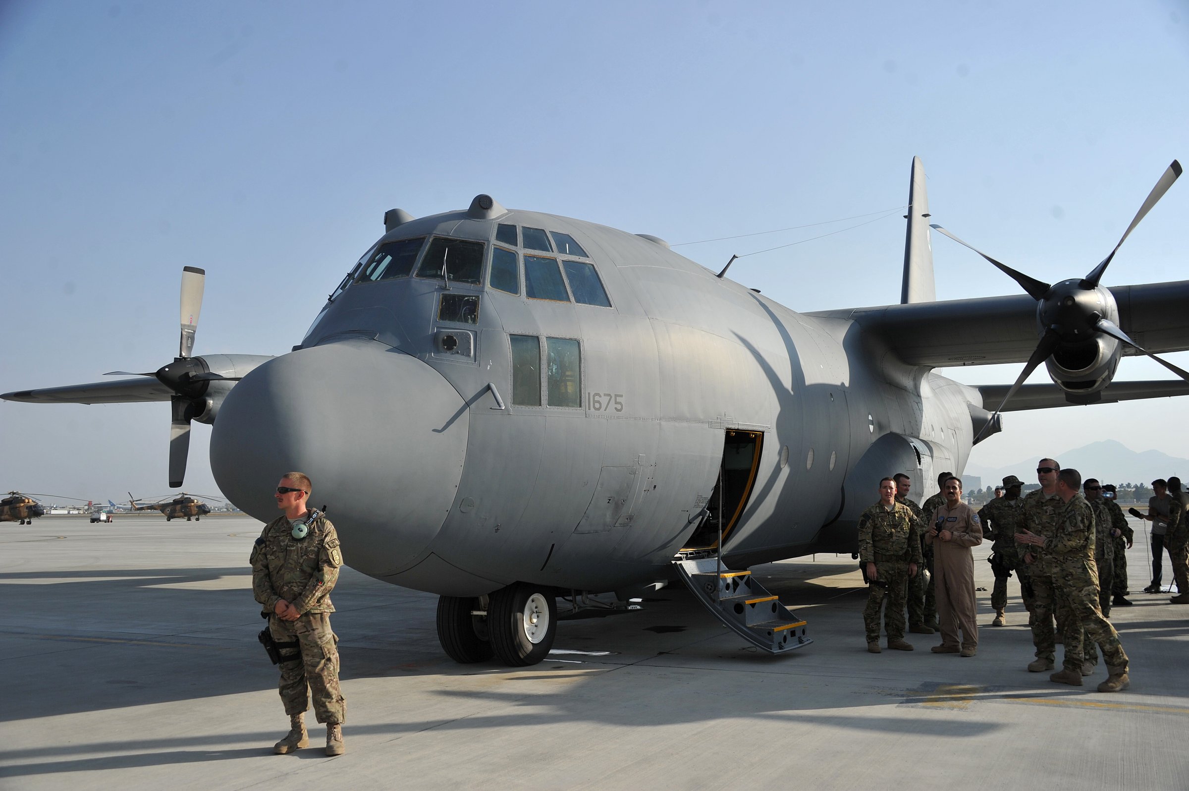 Members of the US Air Force stand alongside a C-130 transport aircraft at Kabul international airport on October 9, 2013.