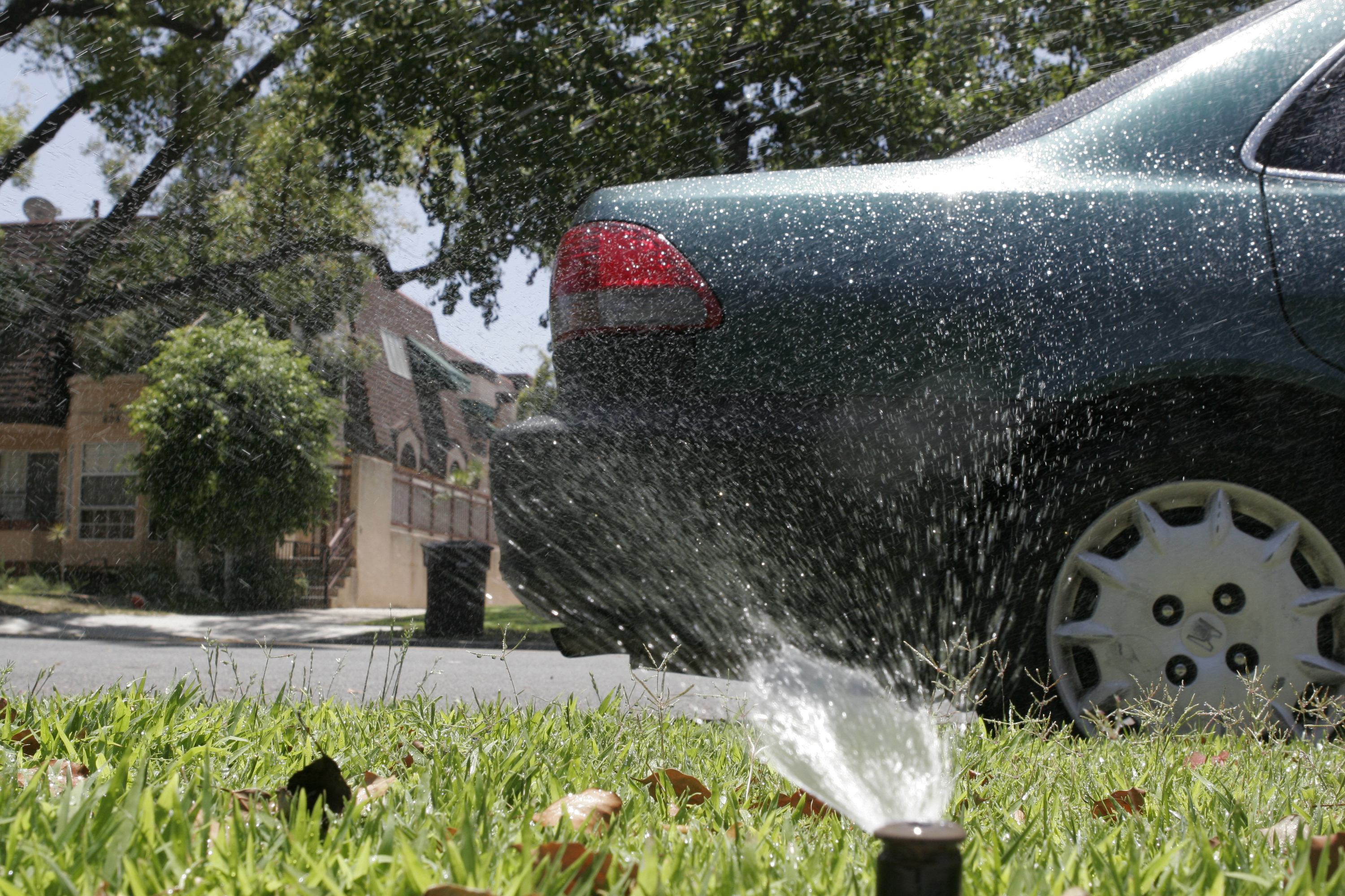 A sprinkler system sprays water onto a parked car along the curb in Glendale, Calif., Wednesday, July 9, 2014. (Matt Hamilton—AP)