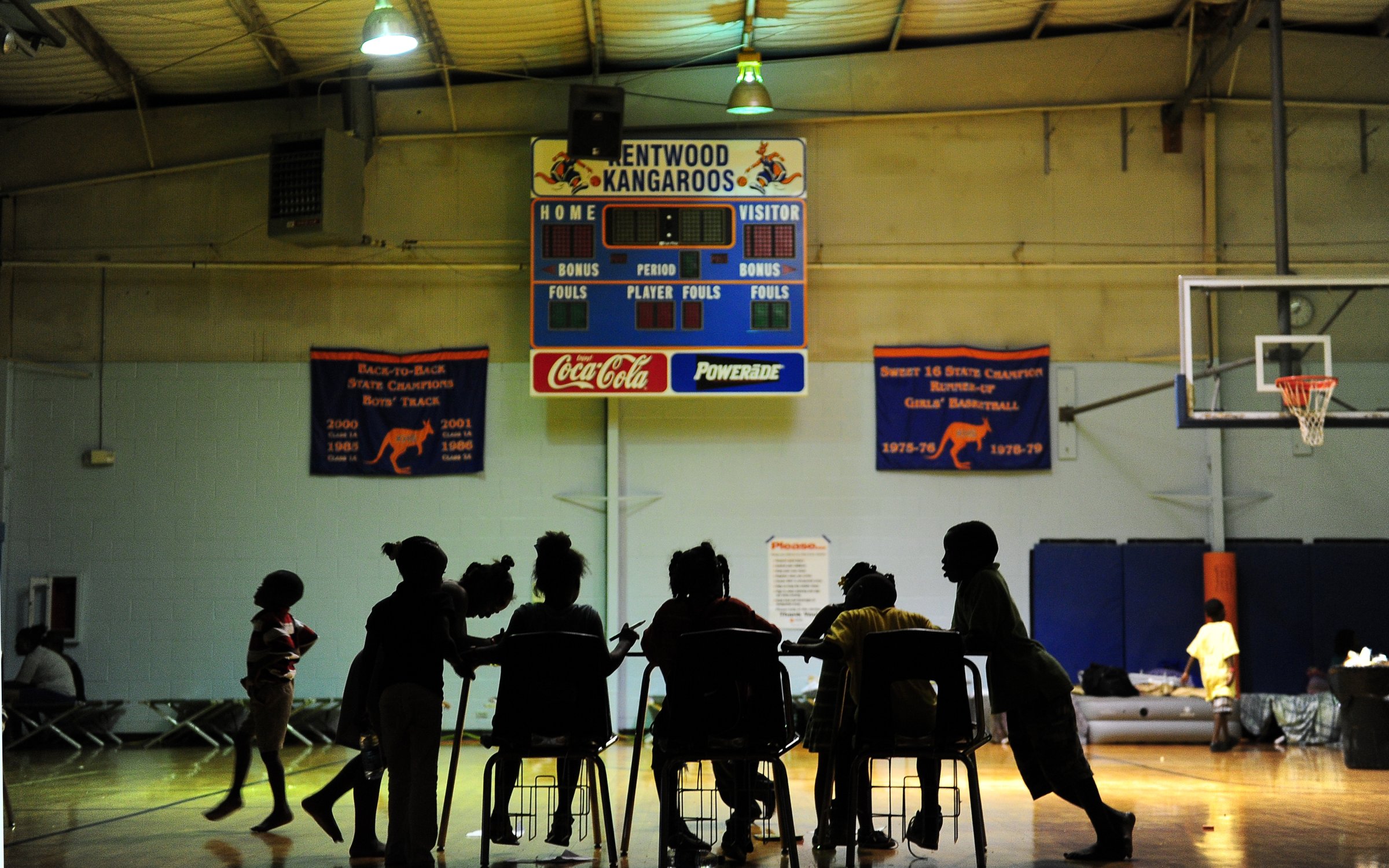Children try to do their homework at an evacuation shelter in a high school gymnasium in Kentwood, Louisiana on August 30, 2012.
