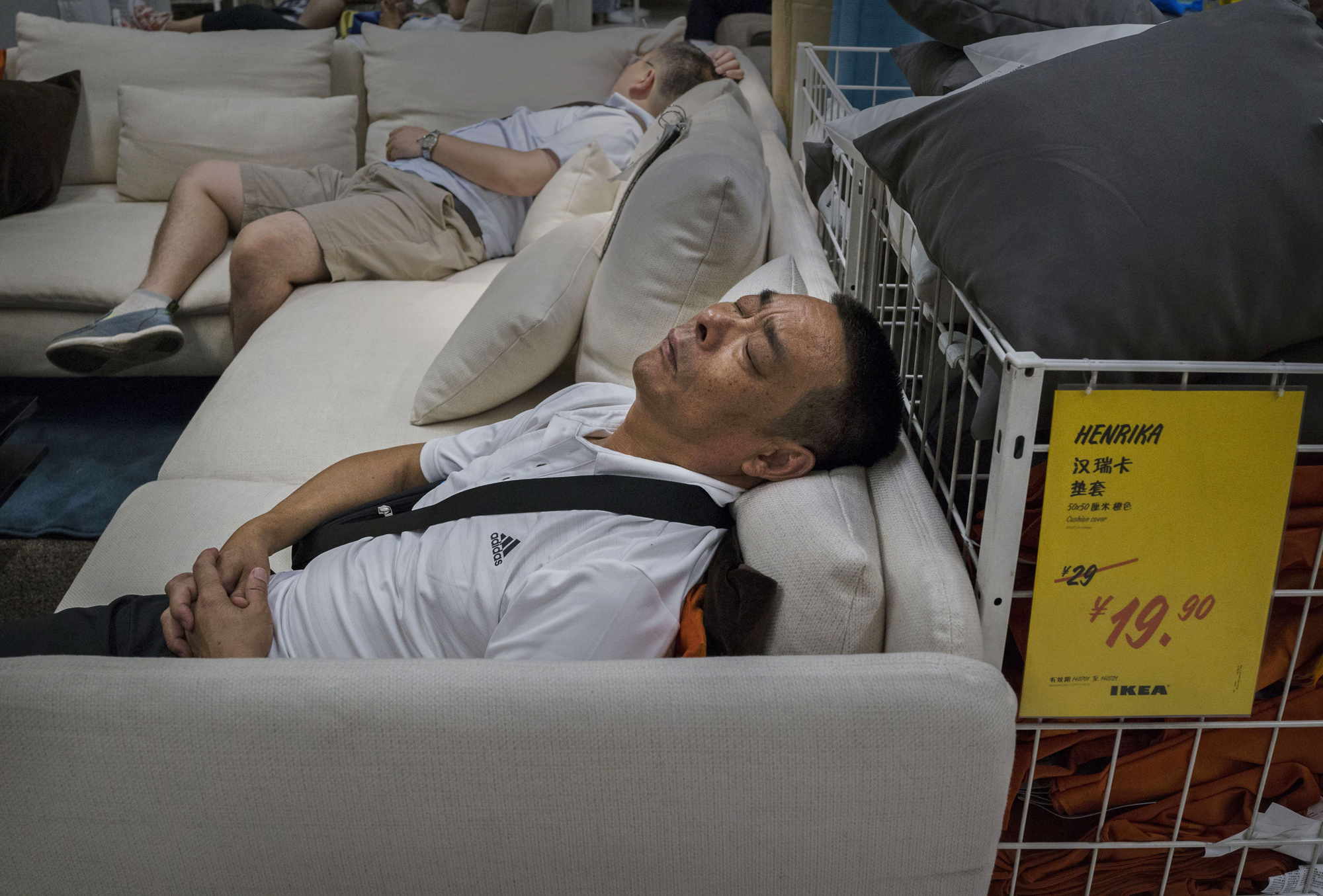 Shoppers sleep on a sofa in the showroom of the IKEA store on July 6, 2014 in Beijing.