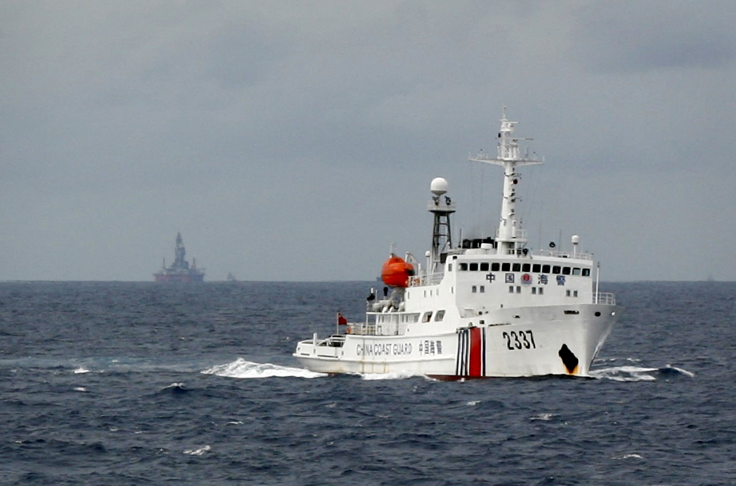 Chinese Coast Guard vessel passes near the Chinese oil rig Haiyang Shi You 981 in the South China Sea