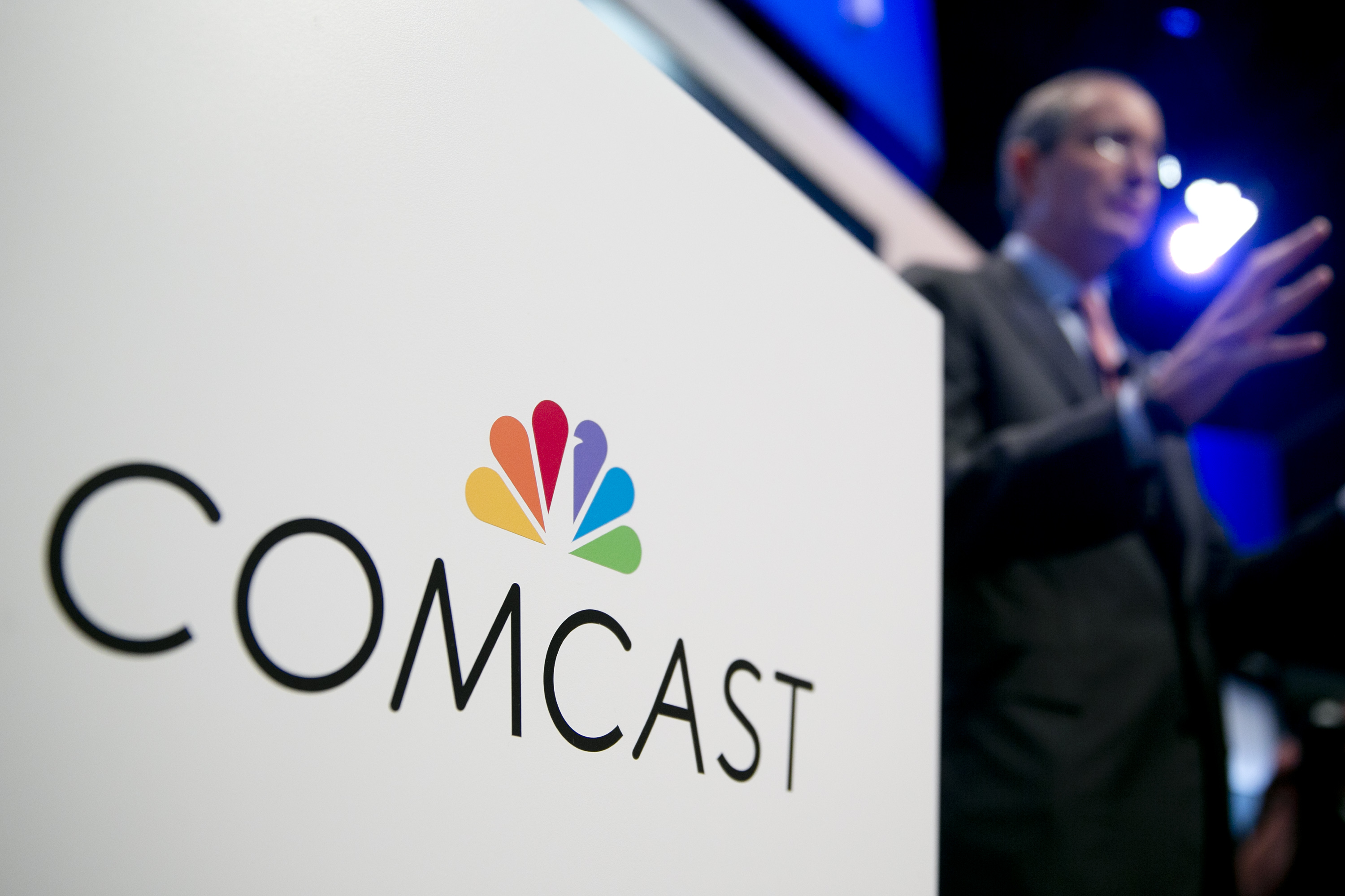 The Comcast Corp. logo is seen as Brian Roberts, chairman and chief executive officer of Comcast Corp., right, speaks during a news conference at the National Cable and Telecommunications Association (NCTA) Cable Show in Washington, D.C., U.S., on Tuesday, June 11, 2013. (Bloomberg—Bloomberg via Getty Images)