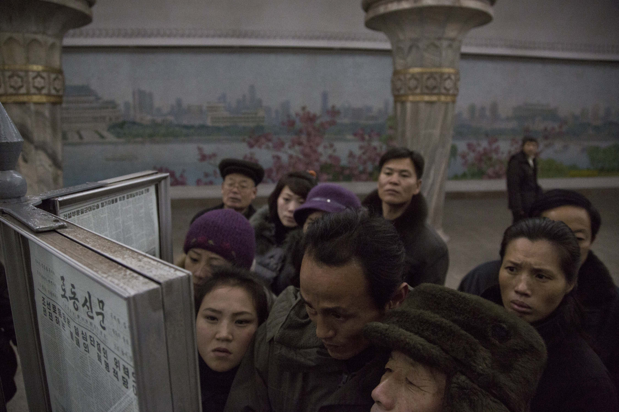 North Korean subway commuters gather around a public newspaper stand on the train platform in Pyongyang, North Korea,  Dec. 13, 2013 to read the headlines about Jang Song Thaek, North Korean leader Kim Jong Un's uncle who was executed as a traitor.