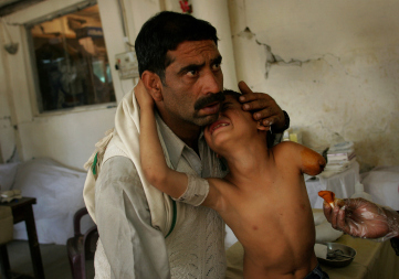 Sabir Hussein Shah holds his nine-year-old son Zeeshan, who was injured in the Oct. 8 earthquake, as he is treated after having his arm amputated at a field hospital in Muzaffarabad, Pakistan, Oct. 30, 2005. The photo was awarded the 1st prize in the General News Singles category in the 2006 World Press Photo contest. (David Guttenfelder—AP)