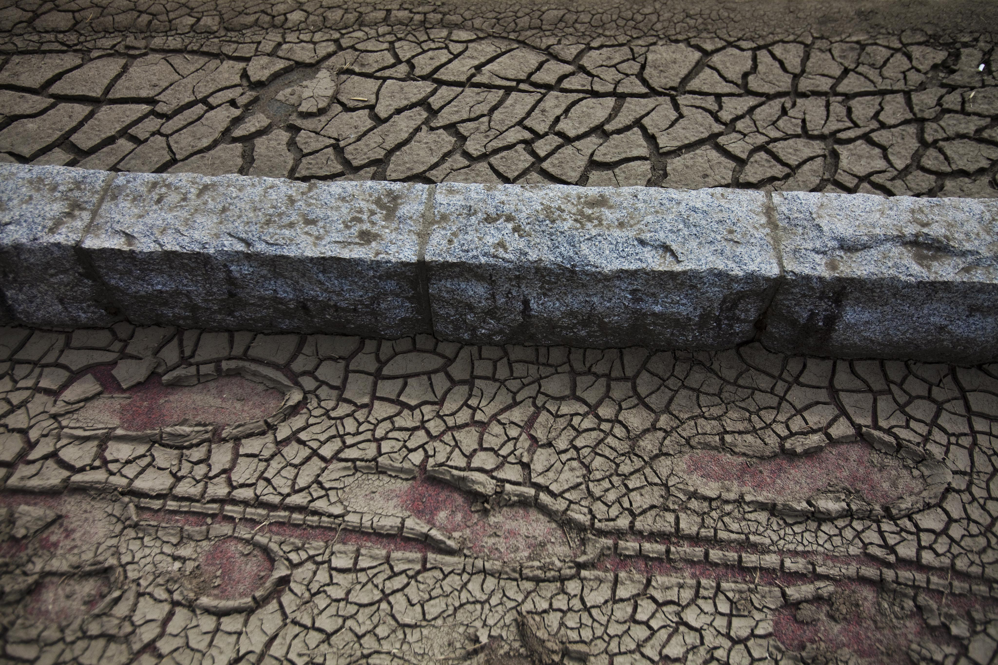 Footprints are left in the dried mud of a street of the Odaka area of Minamisoma, inside the deserted evacuation zone established for the 20 kilometer radius around the Fukushima Dai-ichi nuclear reactors, April 7, 2011.