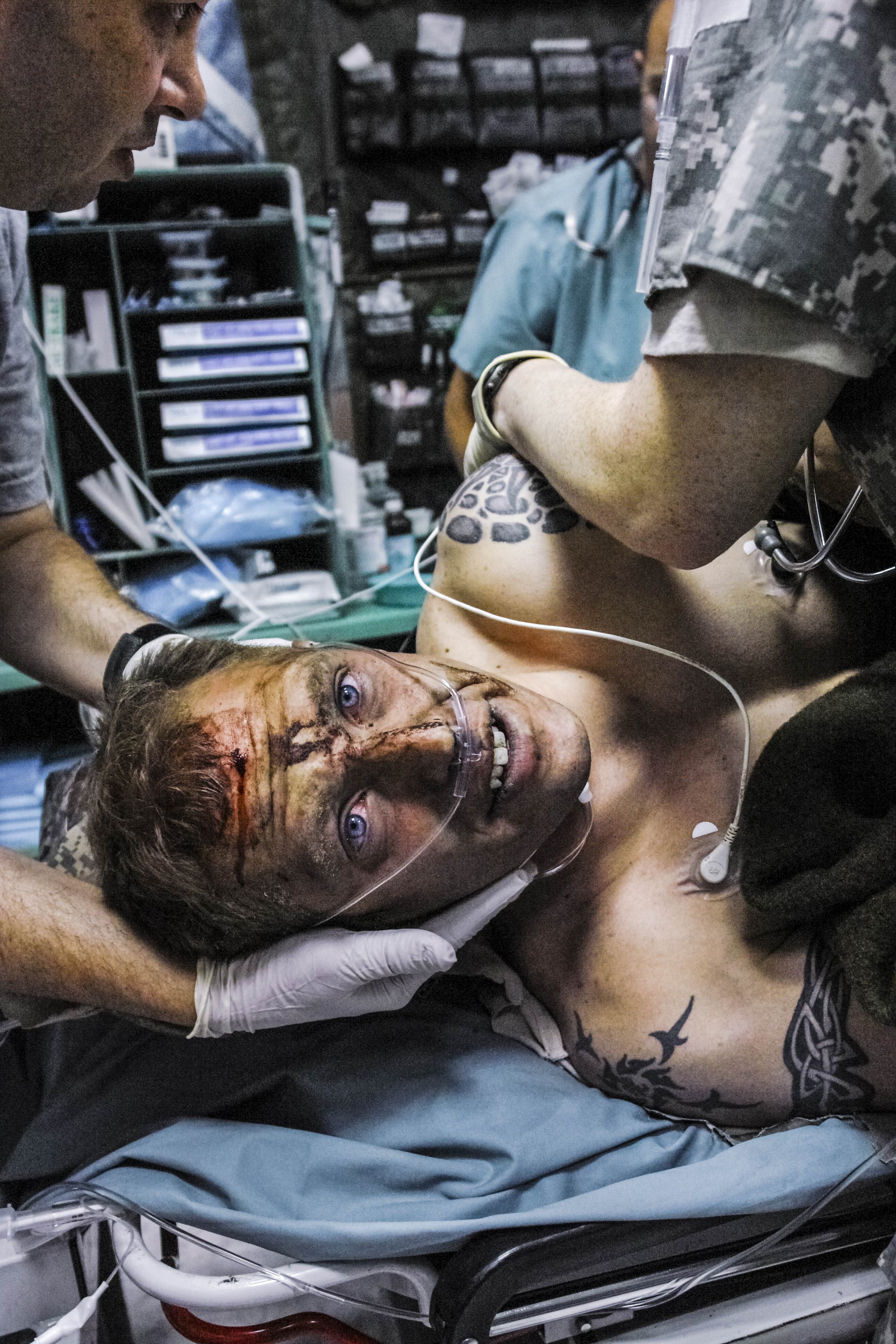 Sergeant Jeff Reffner, minutes after being wounded in an explosion. He had been on a convoy
                              sweeping for IEDs when his commander ordered the driver to speed up. They were moving too
                              fast to see the bomb on the road. When he recovered consciousness moments after the blast,
                              Reffner tried to lift his leg and it just “folded in half.” He spent several years at Walter Reed
                              Hospital and has had thirty-one surgeries on the leg. Although he is in good spirits and able to
                              walk, doctors have told him that he may suffer from chronic pain for the rest of his life. He has
                              no regrets, saying, “I’d rather me get hurt than one of my friends.”
                              Baghdad, Iraq. 2006