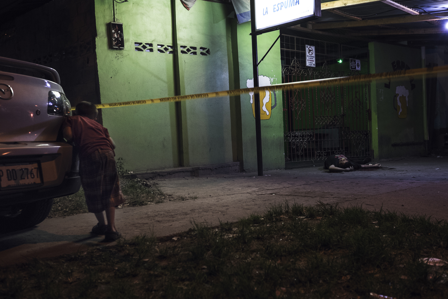 A body in a crime scene wrapped by police tape in San Pedro Sula. Honduras. July 18, 2014.