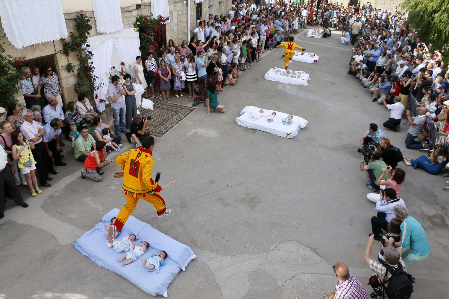 A man dressed up as the devil jumps over babies lying on a mattress in the street during 'El Colacho', the 'baby jumping festival' on June 22, 2014 in the village of Castrillo de Murcia, near Burgos, Spain.