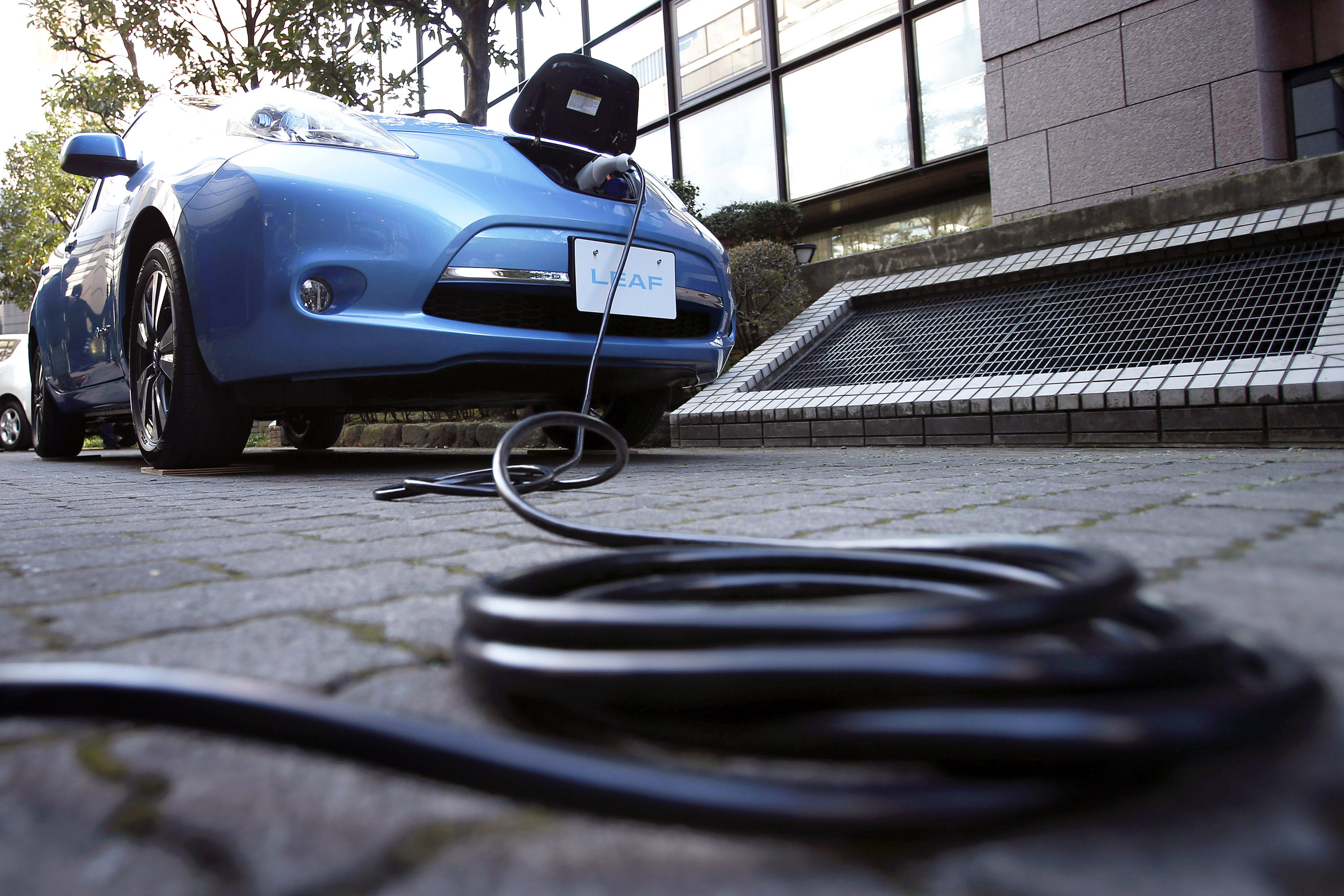 An electric charging cable is seen connected to the updated Nissan Leaf vehicle during a news conference in Japan, Tokyo, on Tuesday, Nov. 20, 2012.
