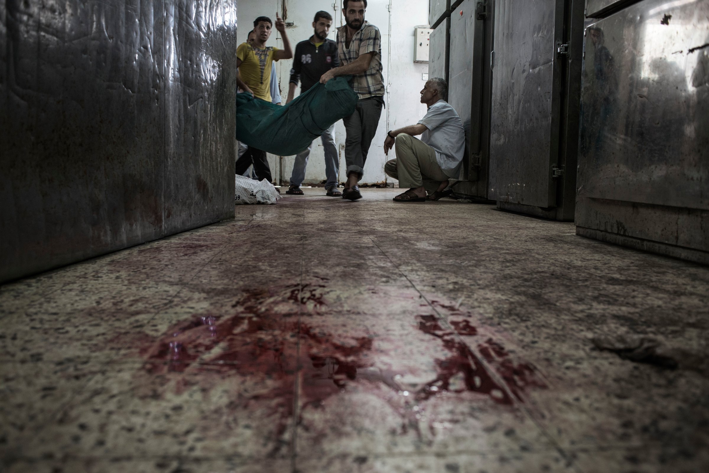 Palestinians carry a body into the Shifa Hospital morgue, Gaza City, July 20, 2014.