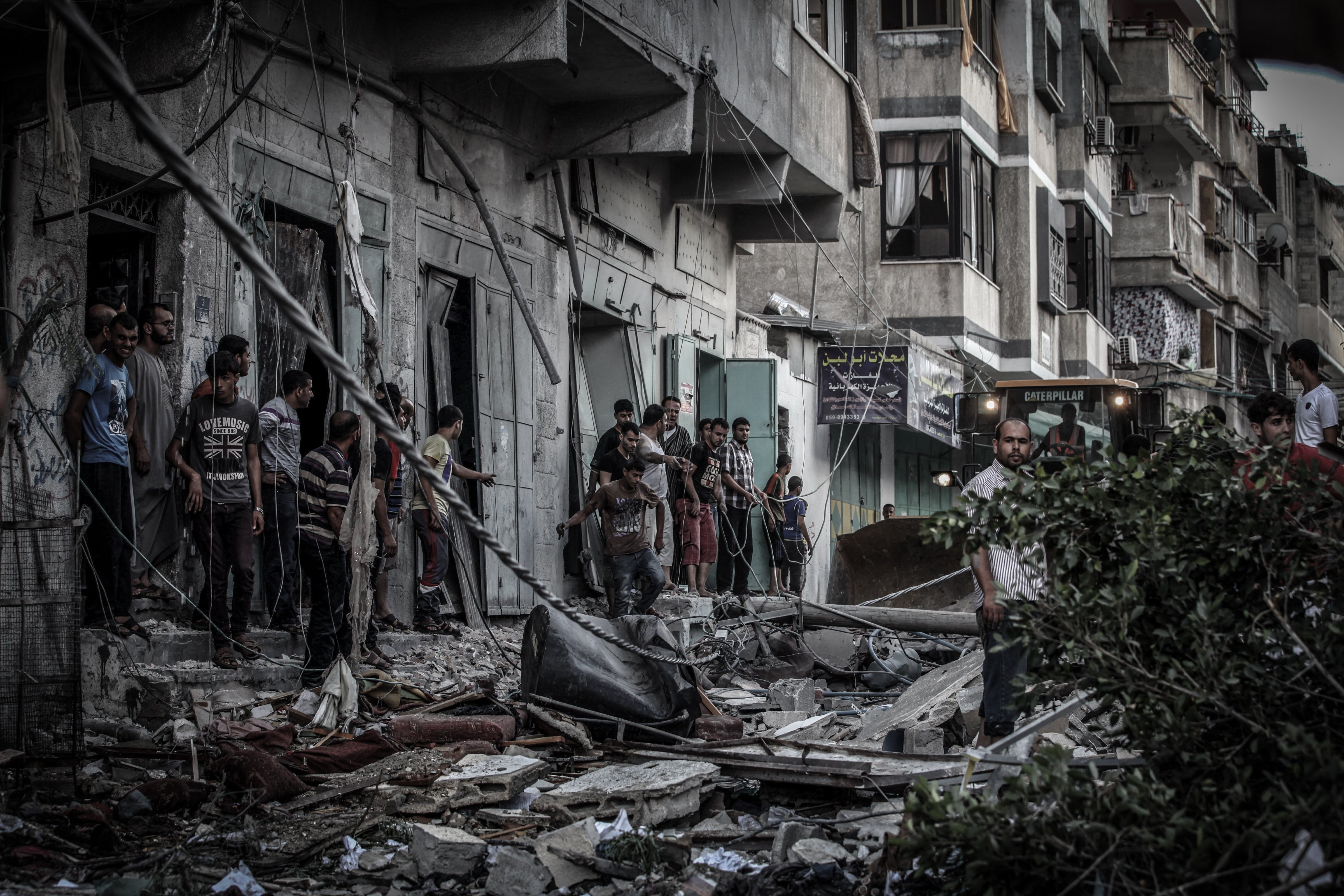 Palestinians inspect damage of an apartment building after it was hit by an Israeli missile strike in Gaza City, Friday, July 18, 2014. (Momen Faiz—NurPhoto/Corbis)