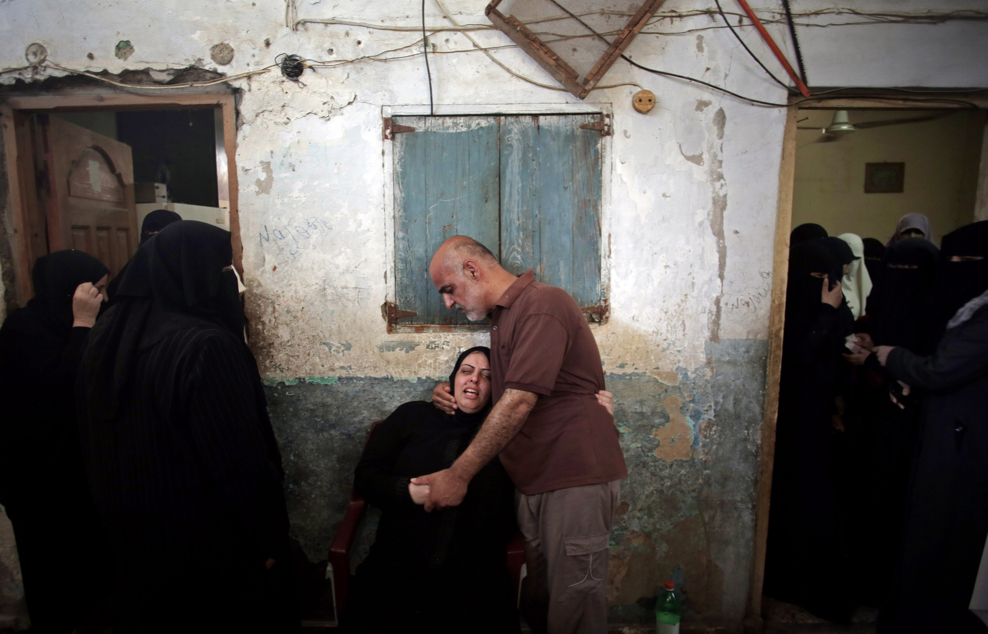 Palestinian relatives of eight members of the Al Haj family, who were killed in a strike early morning, grieve in the family house during their funeral in Khan Younis refugee camp, southern Gaza Strip on Thursday, July 10, 2014. 