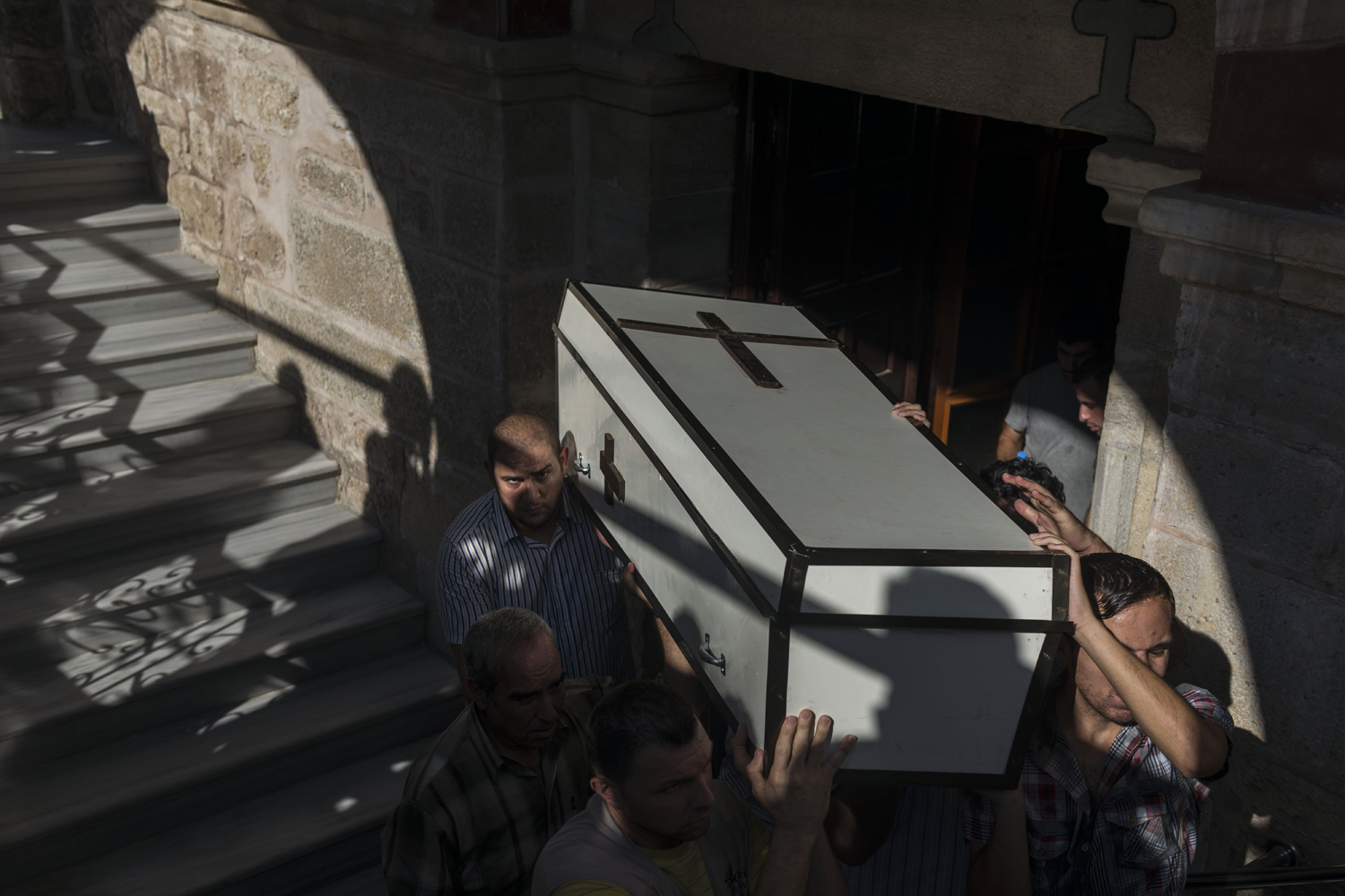 Relatives of Jalila Ayyad, a Christian woman who was reportedly killed during an airstrike, carry her coffin during her funeral at the Church of Saint Porphyrius.