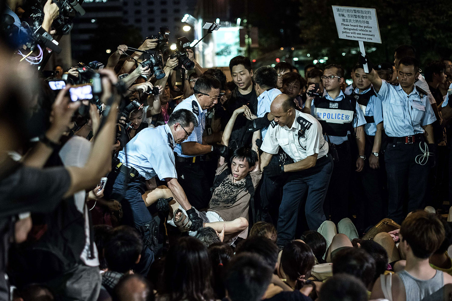 Policemen remove protesters in Central district after a rally seeking greater democracy in Hong Kong on July 2, 2014 (Philippe Lopez—AFP/Getty Images)