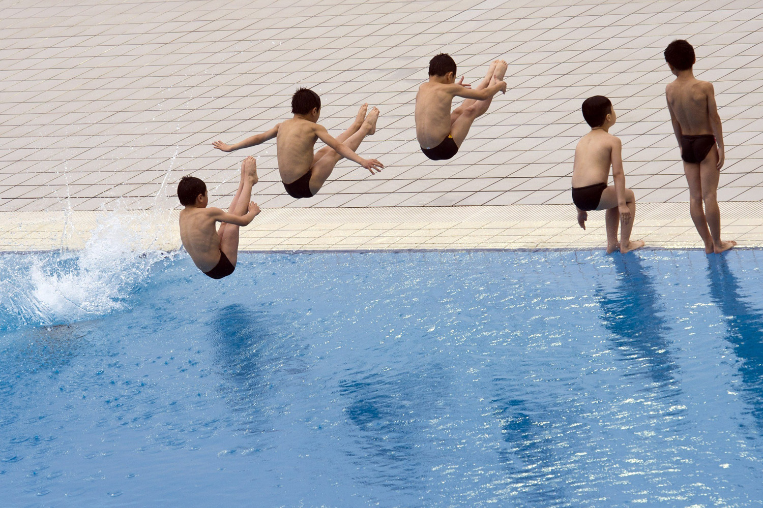 Children jump into the water during the opening ceremony of the 19th FINA Diving World Cup at the Oriental Sports Center in Shanghai on July 15, 2014.