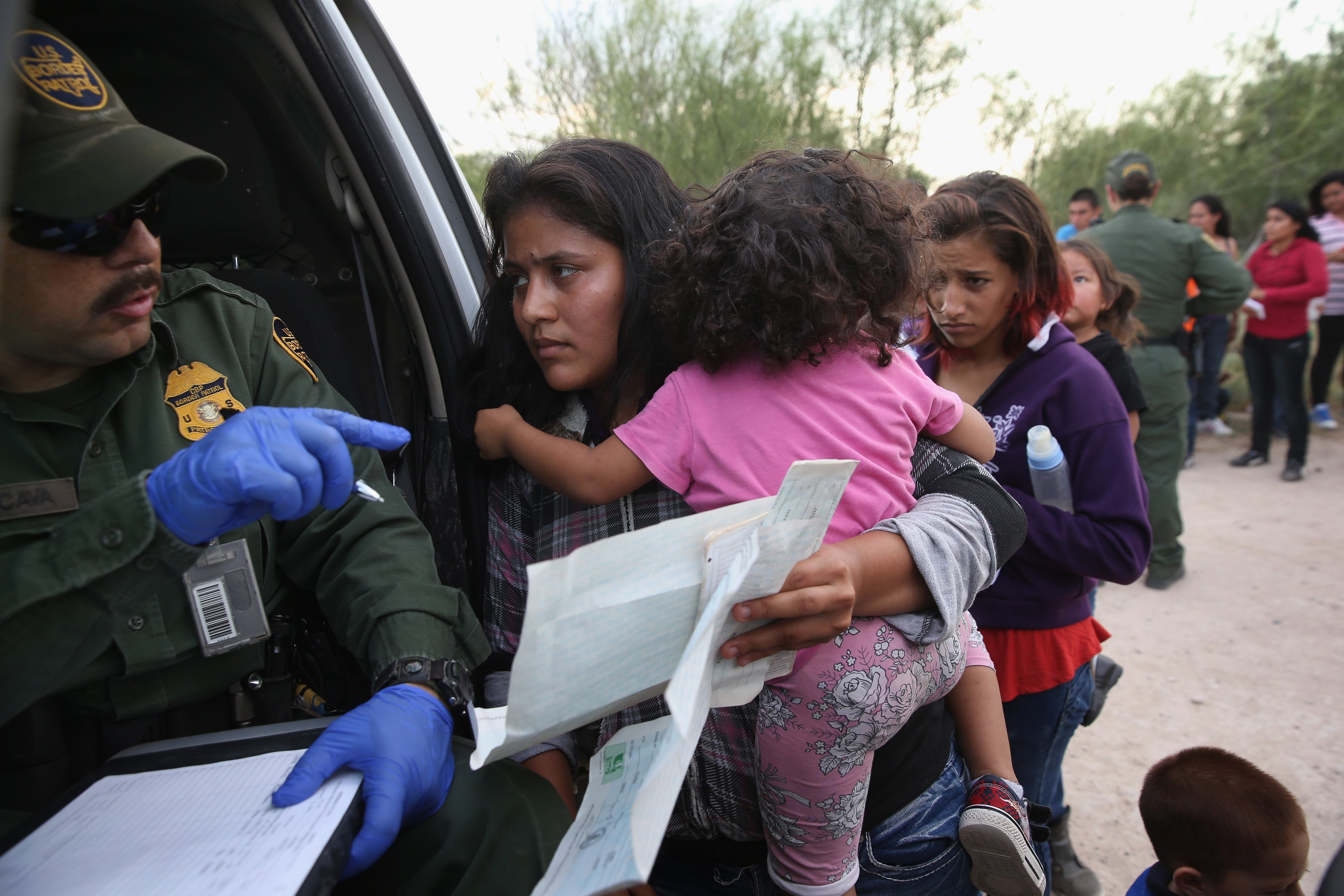 Immigrant Melida Patricio Castro from Honduras shows a birth certificate for her daughter Maria Celeste, 2, to a U.S. Border Patrol agent near the U.S.-Mexico border near Mission, Texas on July 24, 2014. (John Moore—Getty Images)