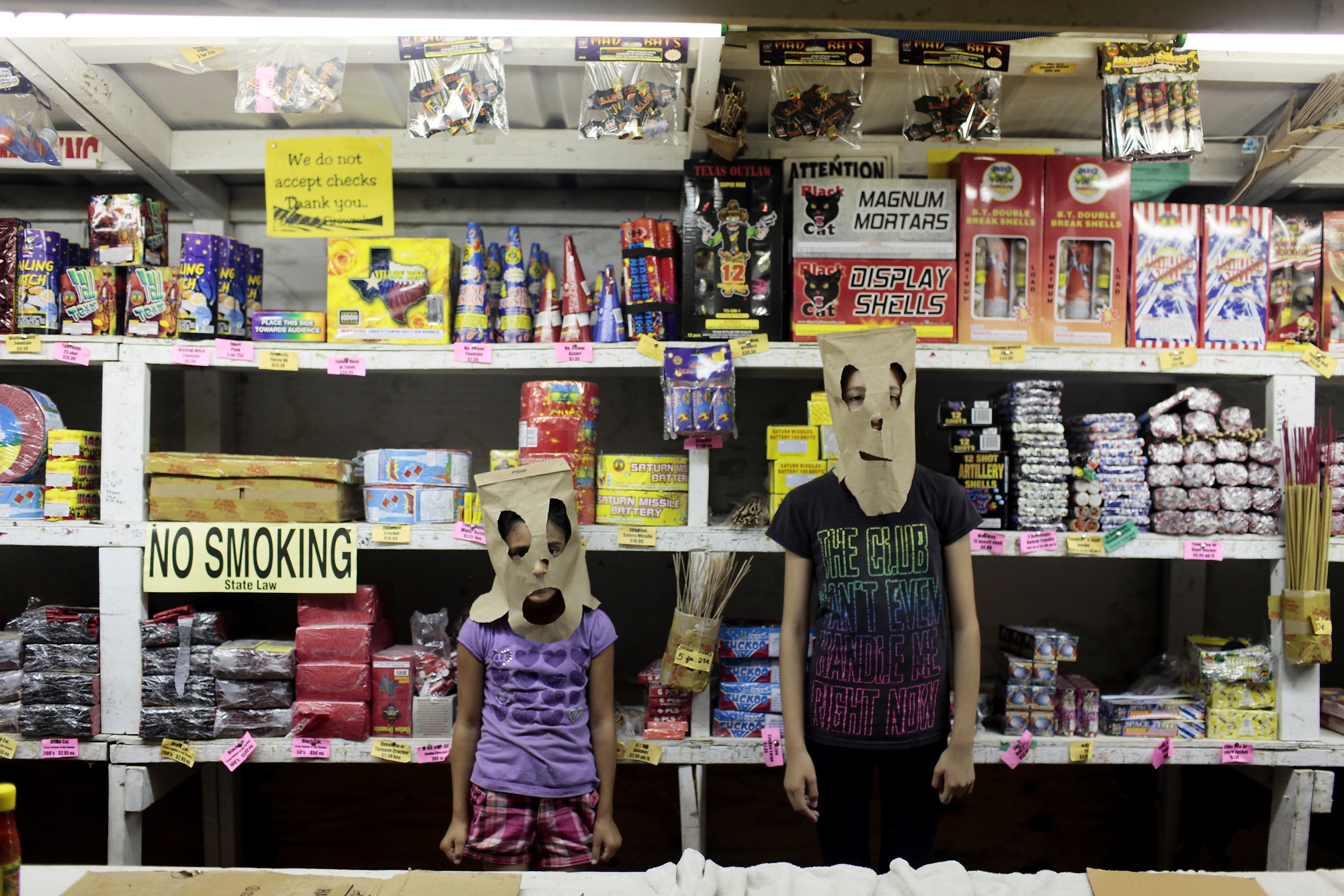 Jazlyn and Briana make masks from the bags provided by the  fireworks company, Hidalgo, Texas, July 1, 2014.