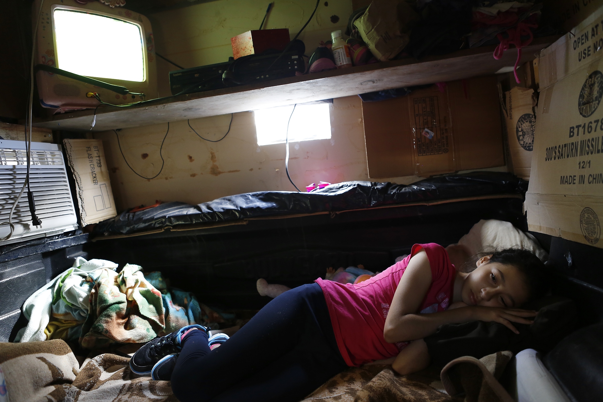 Briana rests during the USA World Cup game in the air-conditioned sleeping compartment attached to the truck that Nelson built, Hidalgo, Texas, July 1, 2014.