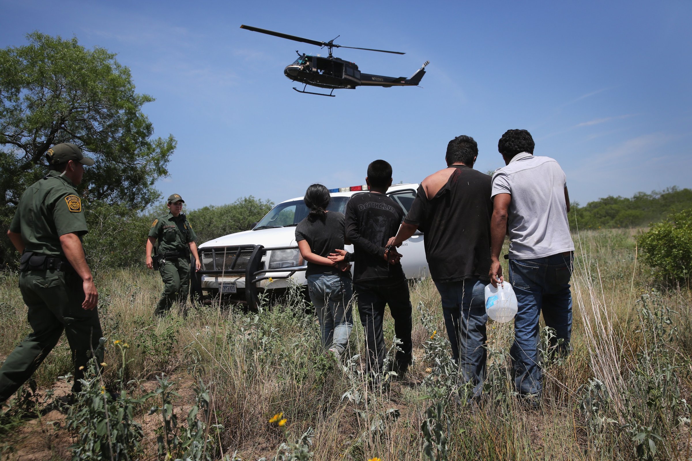 U.S. Customs and Border Protection agents take undocumented immigrants into custody on July 22, 2014 near Falfurrias, Texas.