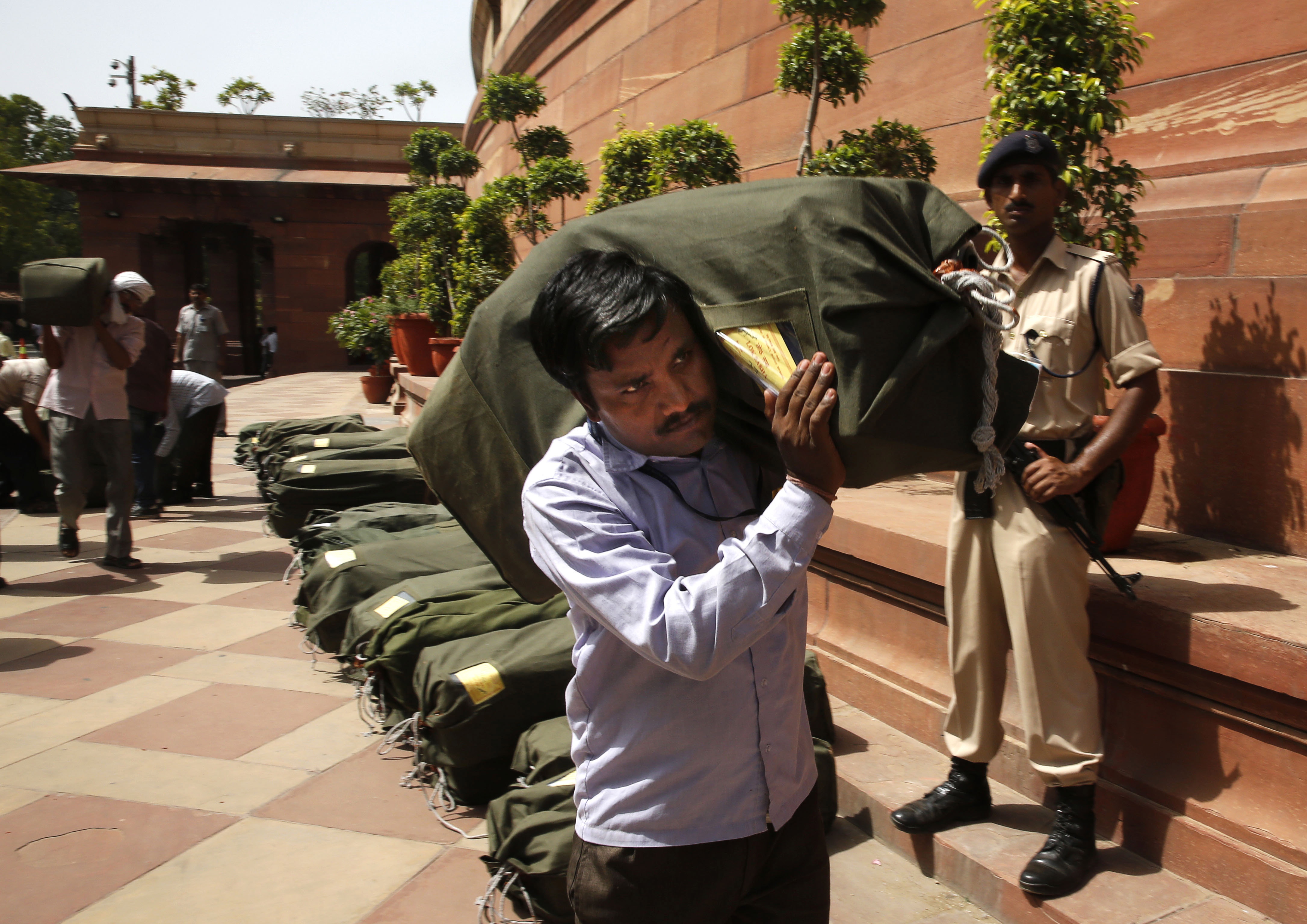 An Indian worker carries a sack containing copies of the 2014-15 union budget at the Indian parliament in New Delhi, Thursday, July 10, 2014. (Manish Swarup—AP Photo)