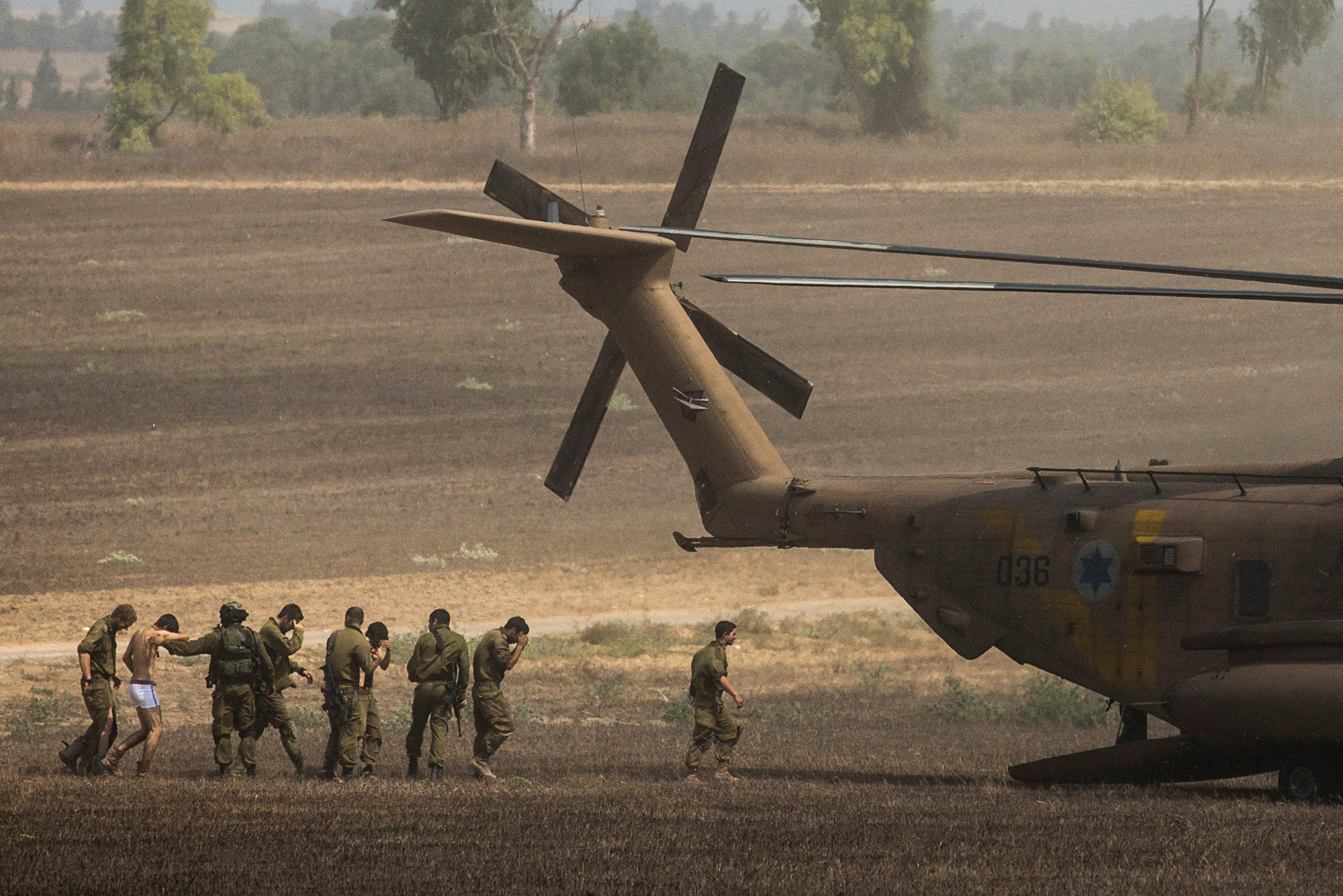 Wounded Israeli soldiers are brought to a helicopter on July 23, 2014 near Kafar Aza, Israel.