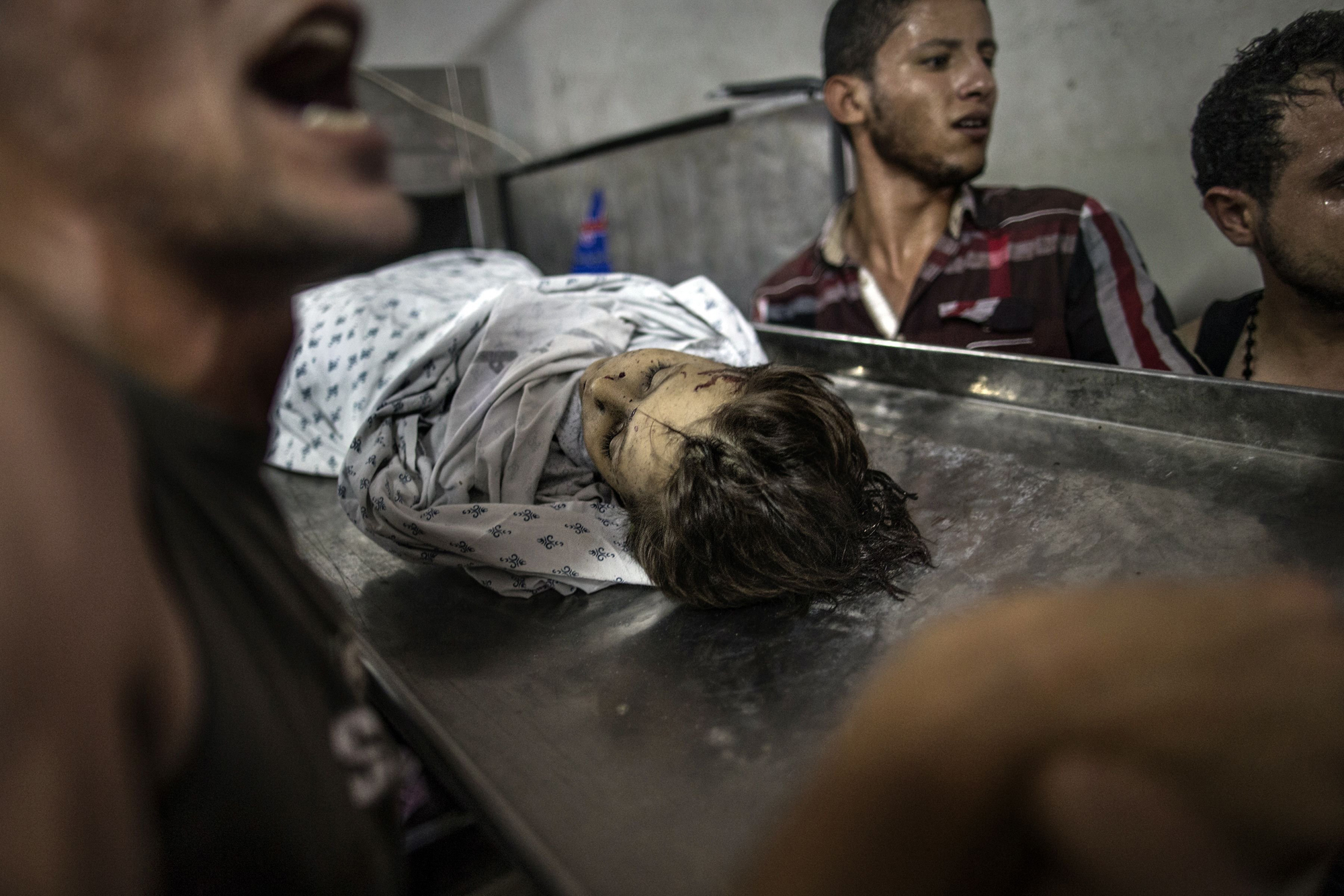 The body of a Palestinian child, killed in an explosion in a public playground on the beachfront of Shati refugee camp, is seen in the morgue of Shifa hospital in Gaza City on July 28, 2014.
