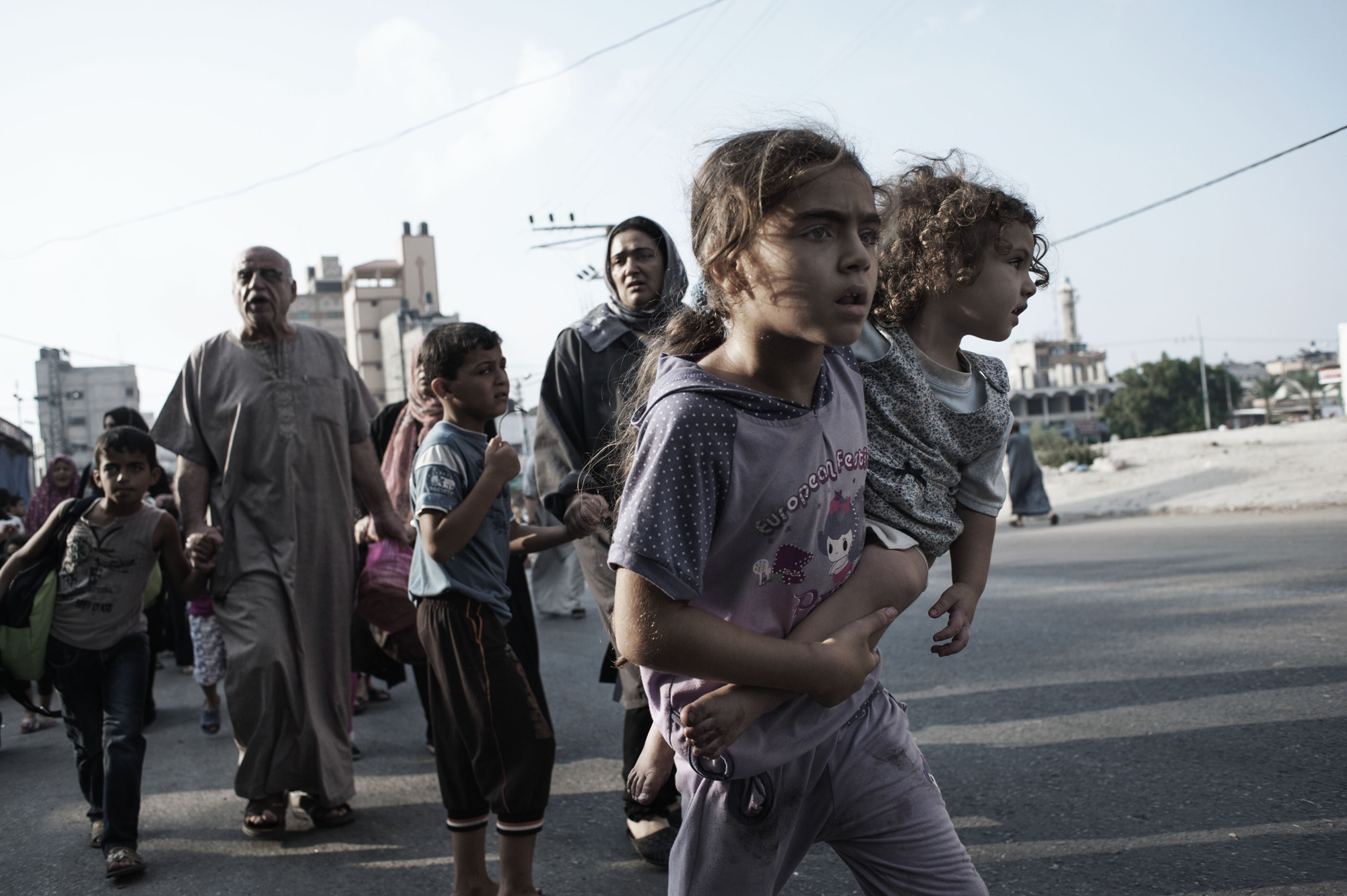 Palestinians flee the Shujayeh neighborhood during heavy shelling in Gaza City. July 20, 2014.