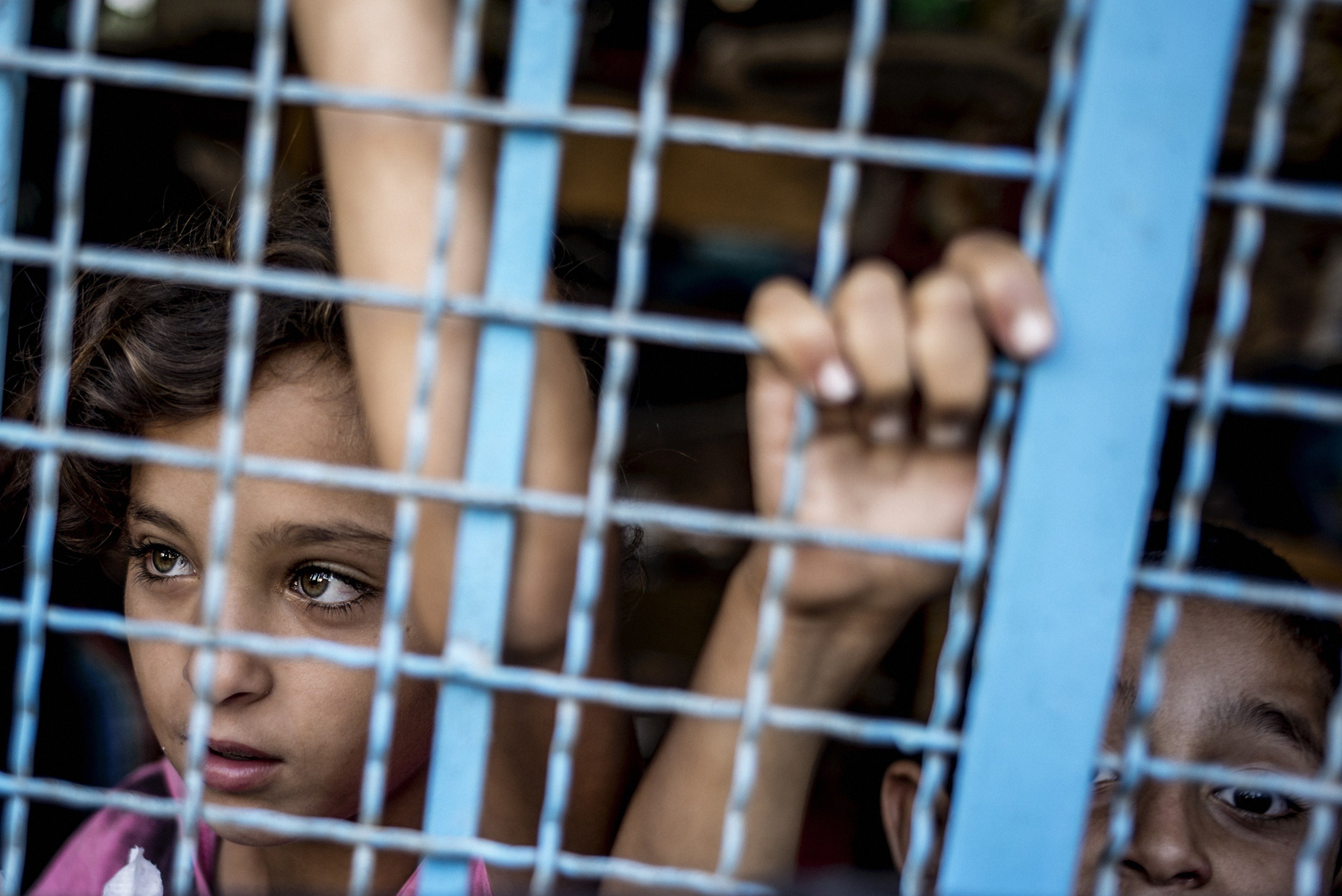 Palestinian girls peers from inside a UN school in Jabalia, north Gaza Strip, on July 25, 2014, where they found shelter after escaping from their home.