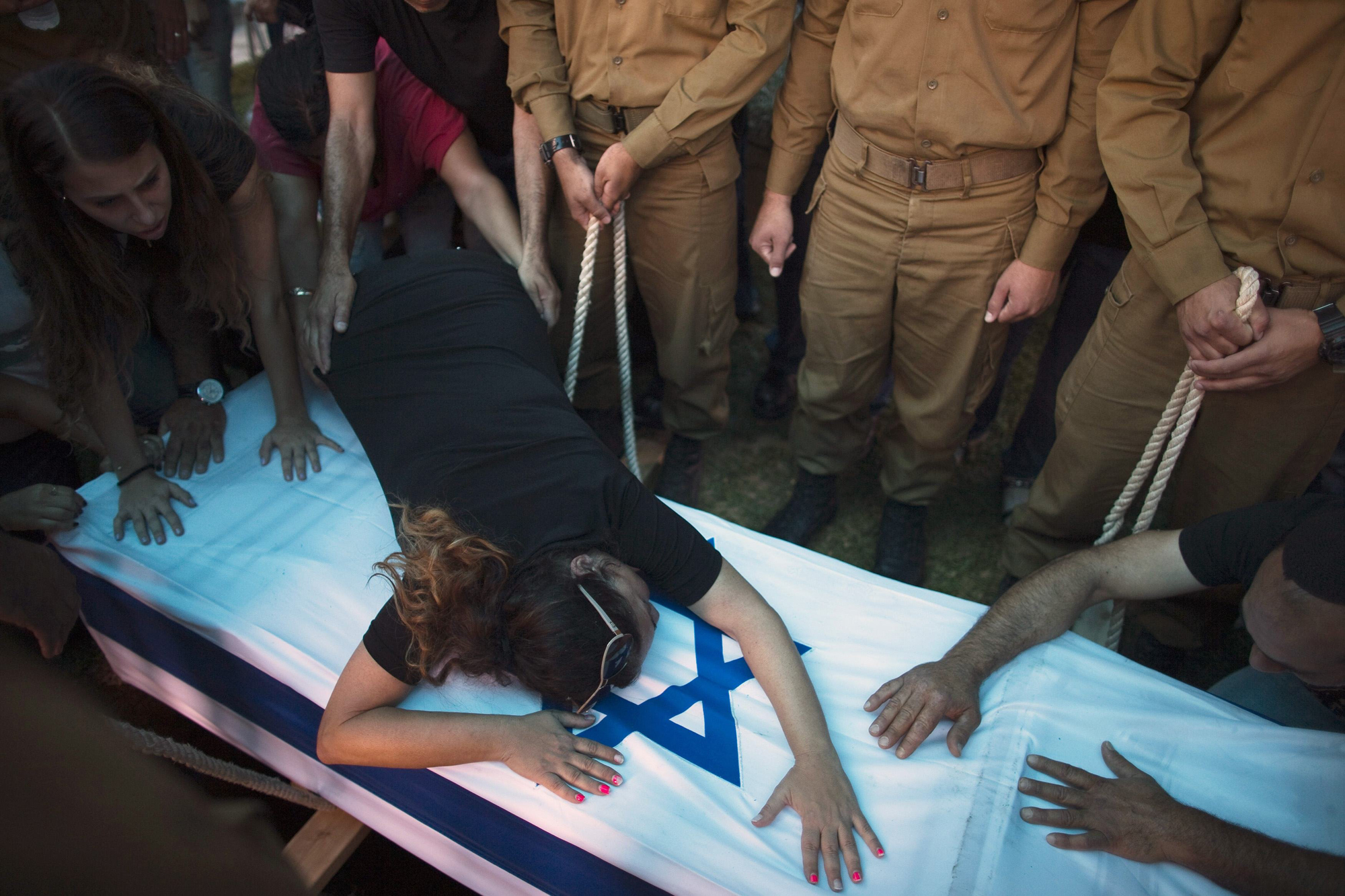 The mother of Israeli soldier Tal Yifrah mourns over his flag-covered coffin during his funeral in Rishon Lezion near Tel Aviv, July 22, 2014.