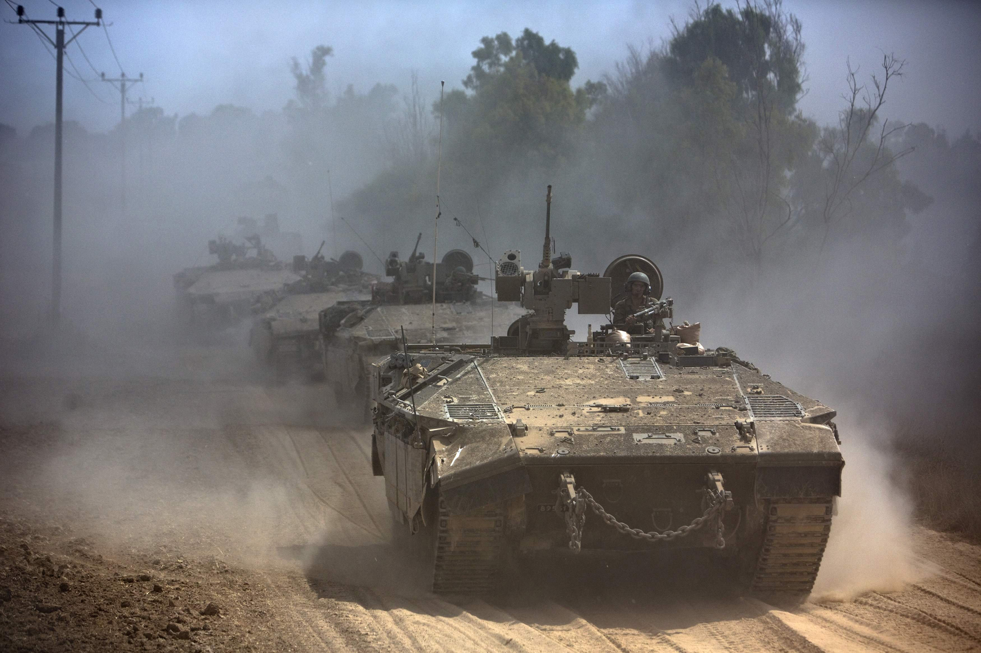 Israeli APCs drive near the Israeli border with Gaza as the come out of the Gaza Strip July 25, 2014.