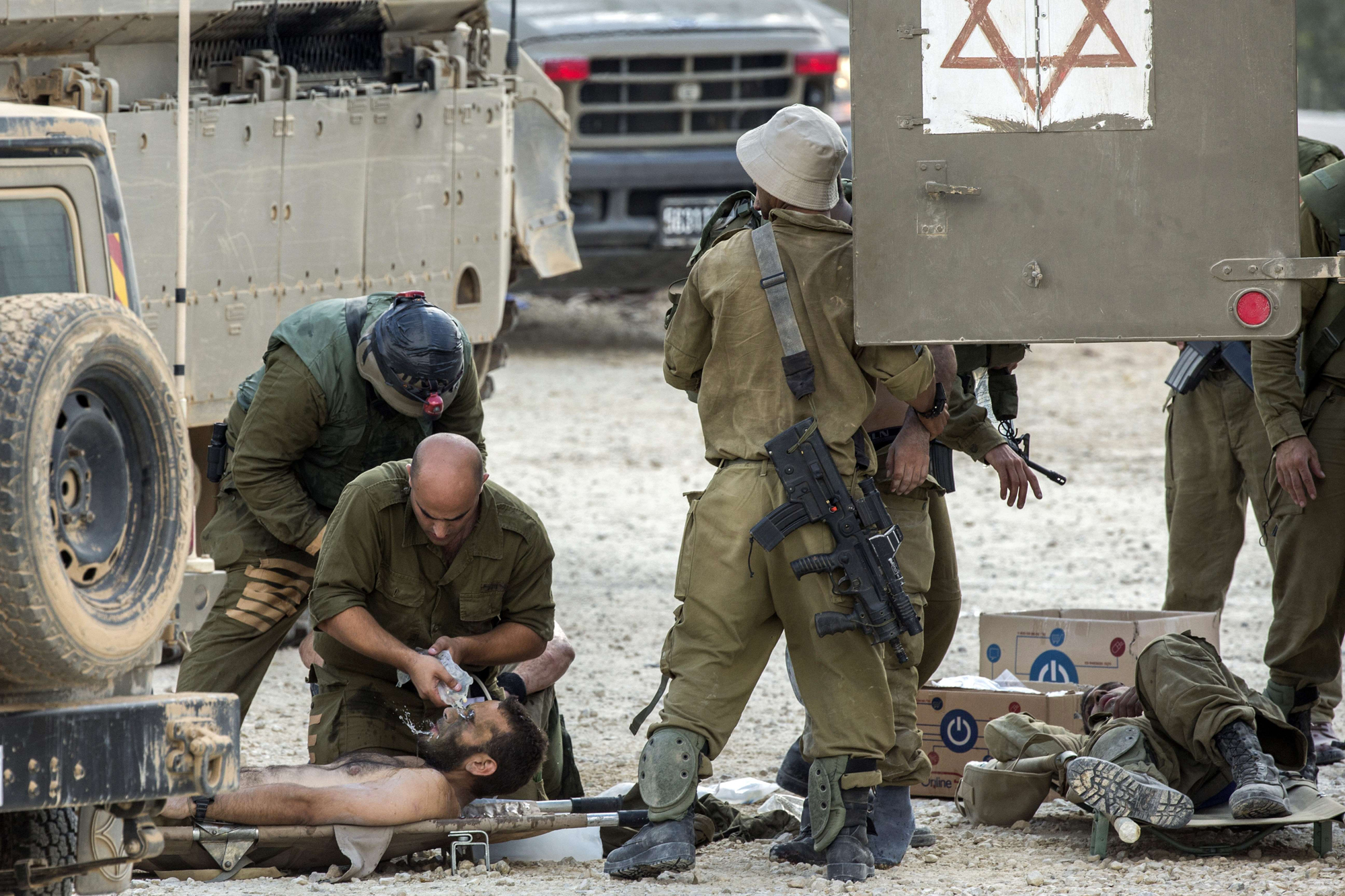 Israeli soldiers evacuate their wounded comrades at an army deployment area near Israel's border with the Gaza Strip, on July 20, 2014.
