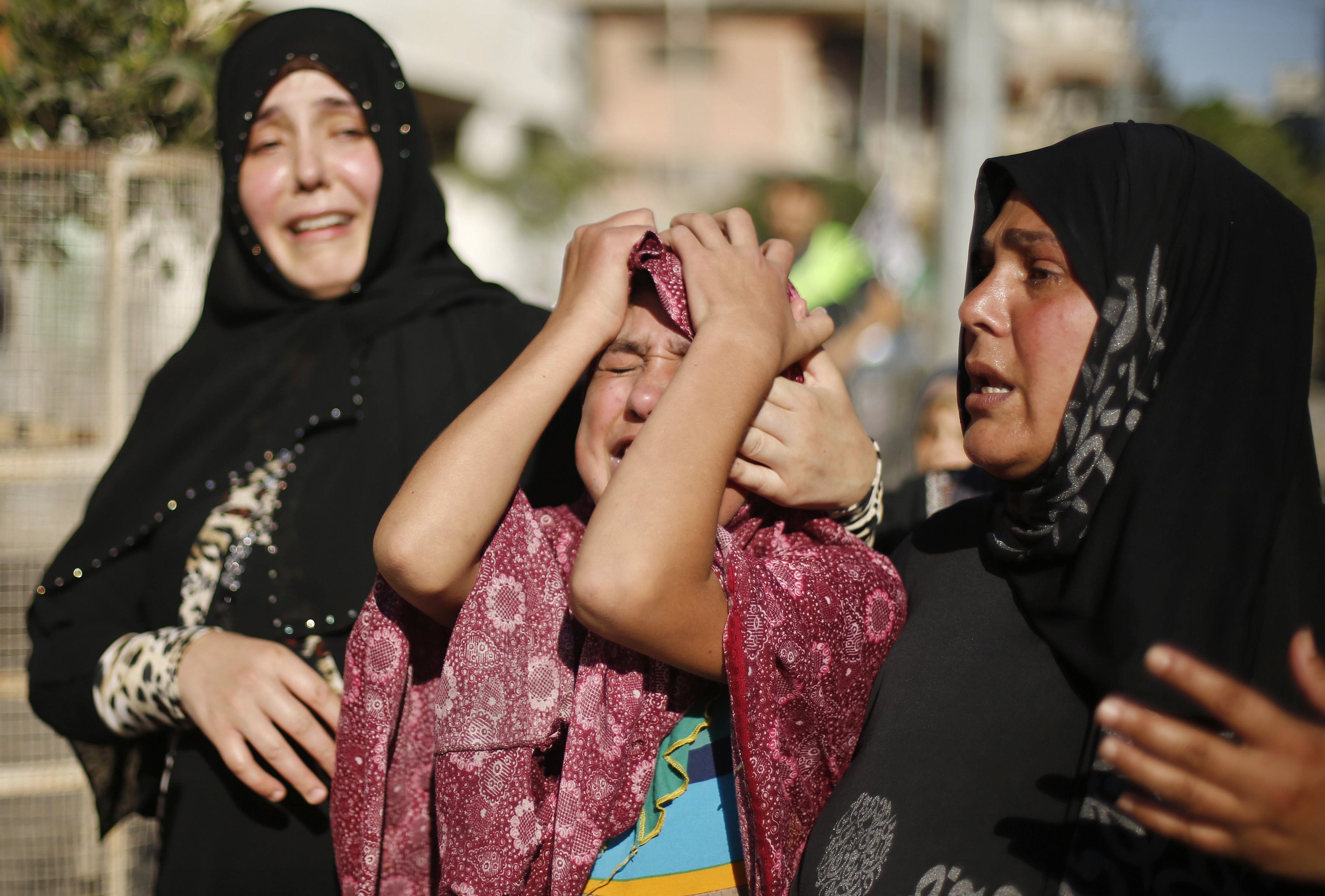 The sister (C) of a Palestinian boy from the Baker family, whom medics said was killed along with three other children from the same family by a shell fired by an Israeli naval gunboat, mourns during their funeral in Gaza City July 16, 2014. (Mohammed Salem—Reuters)