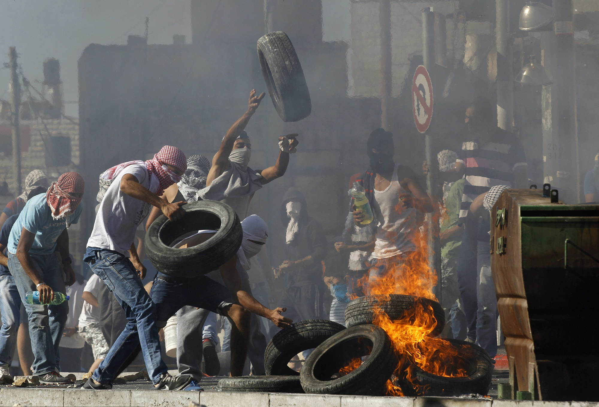 Palestinians set tyres ablaze during clashes with Israeli police in Shuafat, an Arab suburb of Jerusalem July 2.
