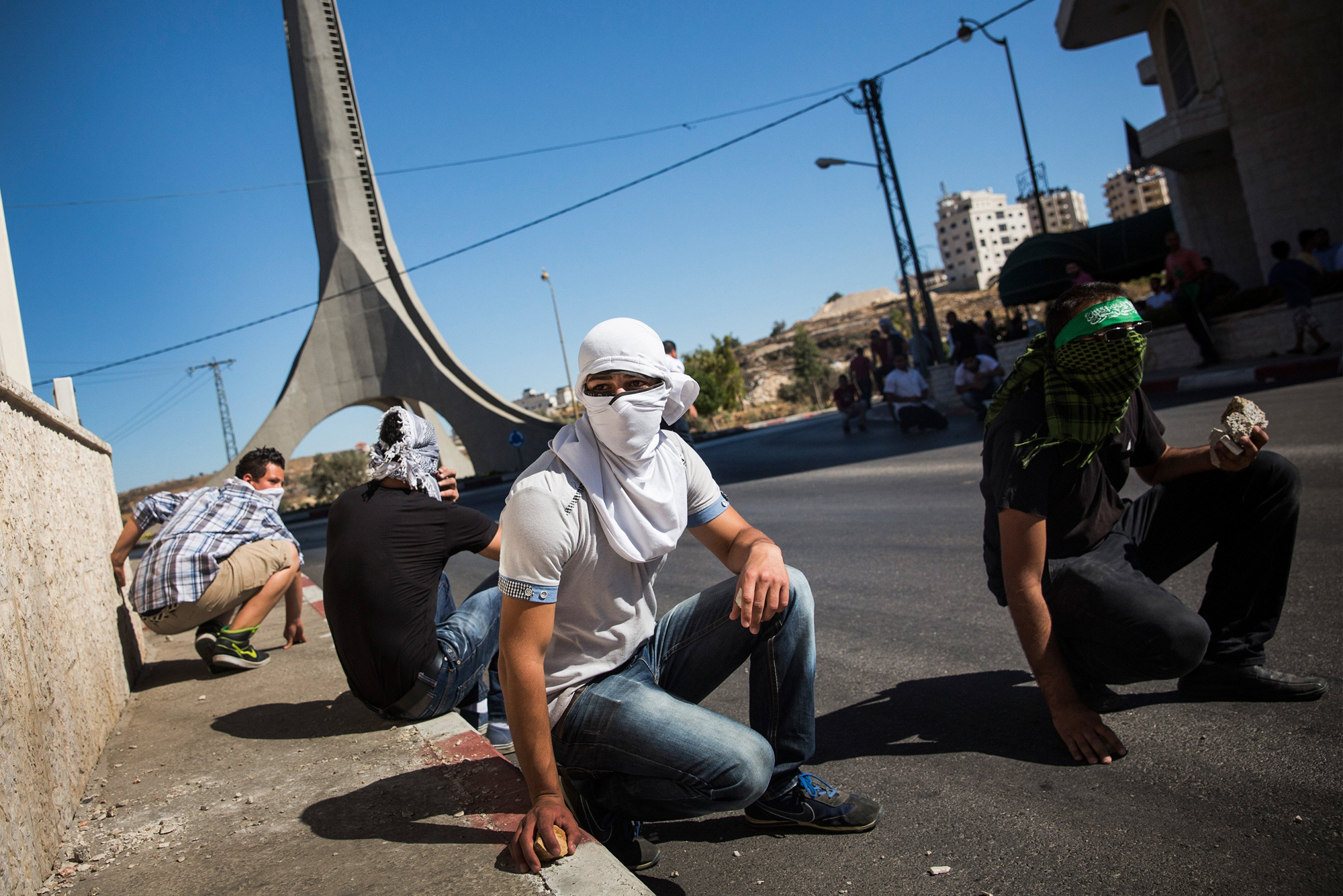 Palestinian supporters of Hamas take shelter while clashing with Israeli security forces on July 25, 2014 near Ramallah, West Bank. (Andrew Burton—Getty Images)