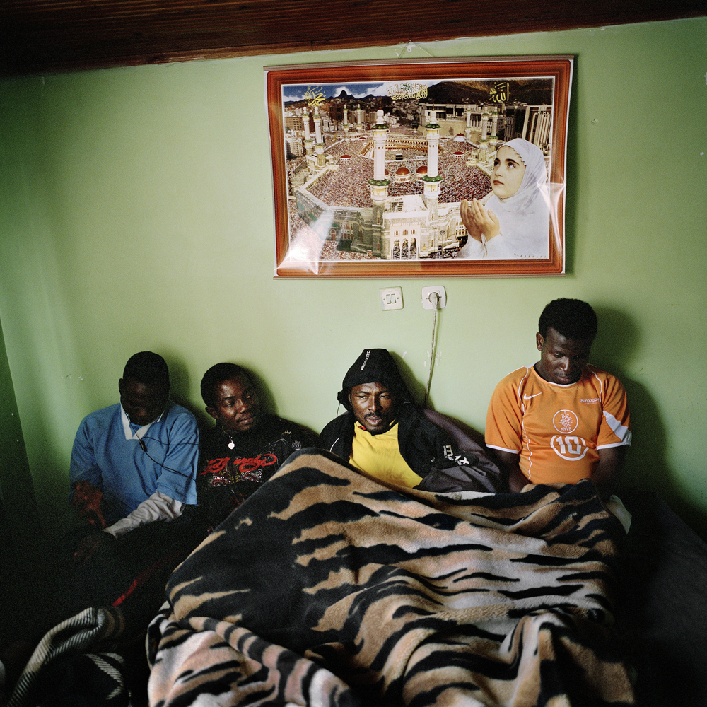 Sodiq, Adegeye and Akeem sit in the bed that they used to share with three other footballers in the small studio apartment that they lived in April 2011 in the Kurtulus neighborhood of Istanbul, Turkey.