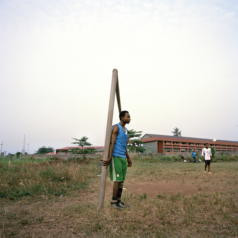 Peter, a footballer with two children and a wife, holds onto the goal post during an afternoon practice at the Government Technical College in February 2014 in Ikorodu, Nigeria.
