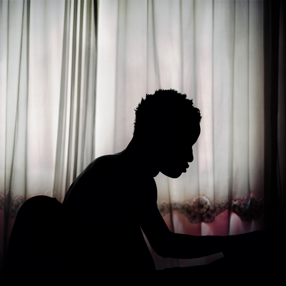 Dayo, 19, a soccer player from Nigeria, sits on his computer inside the bedroom that he shares with another player on January 15, 2014 in the Kurtulus neighborhood of Istanbul.