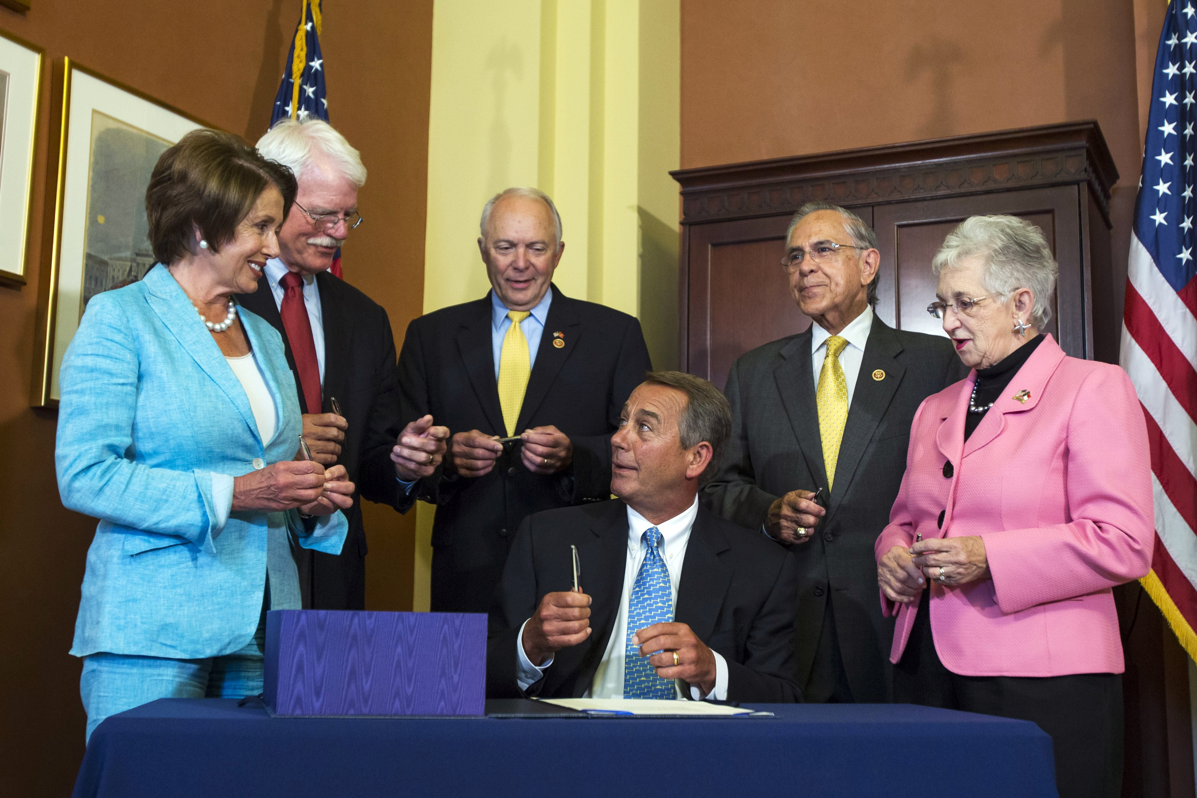 Republican Speaker of the House John Boehner (C) reacts after signing the Workforce Innovation and Opportunity Act with (from left to right) Democratic House Minority Leader Nancy Pelosi, Democratic Congressman George Miller, Republican Congressman John Kline, Republican Congresswoman Virginia Foxx, and Democratic Congressman Ruben Hinojosa in the Speaker's Conference Room in the US Capitol in Washington on July 11, 2014.
