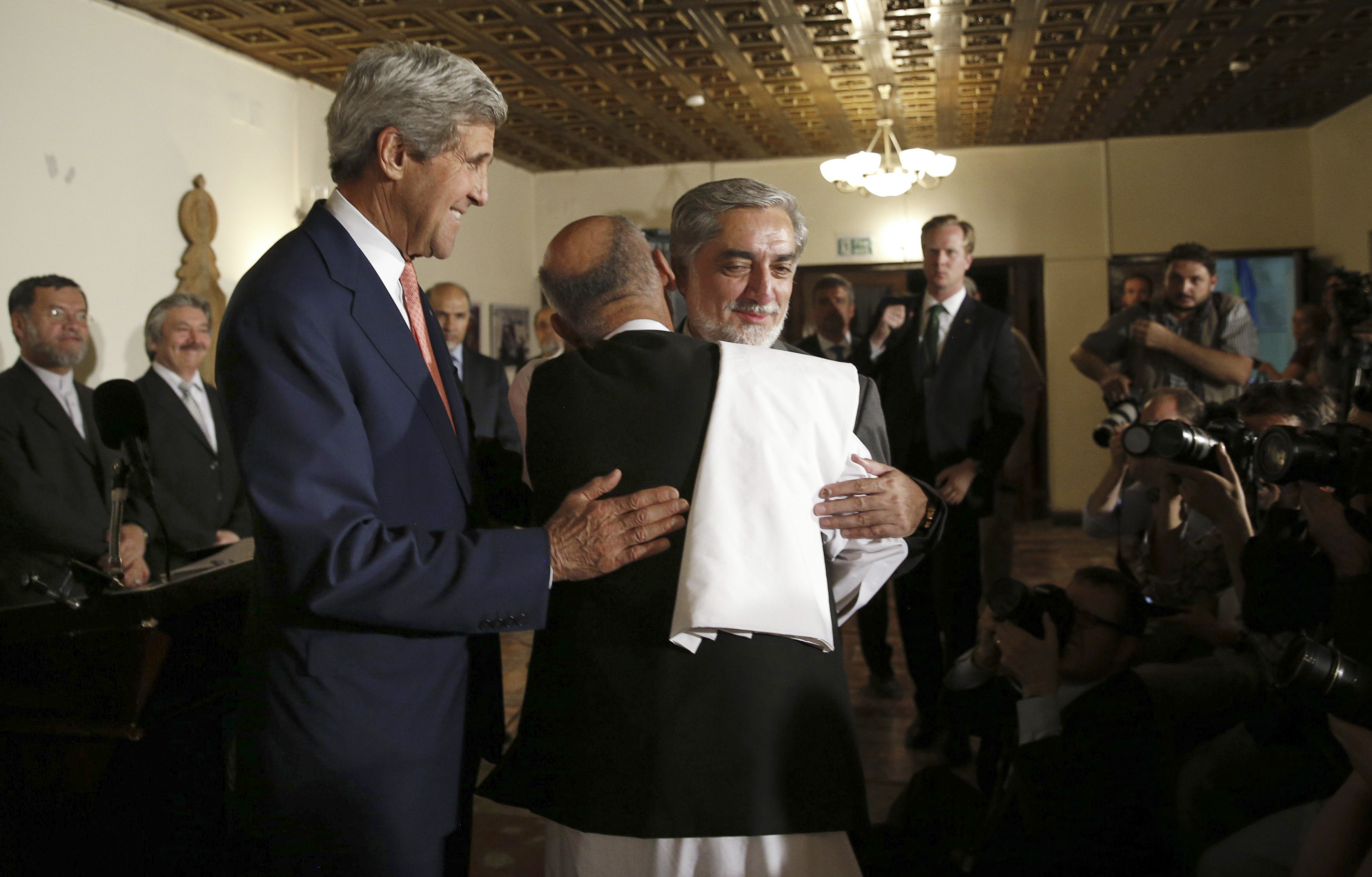 Presidential candidates Abdullah Abdullah, right, and Ashraf Ghani embrace at a news conference with Secretary of State John Kerry where a deal to audit ballots was announced, in Kabul, Afghanistan on July 12, 2014.