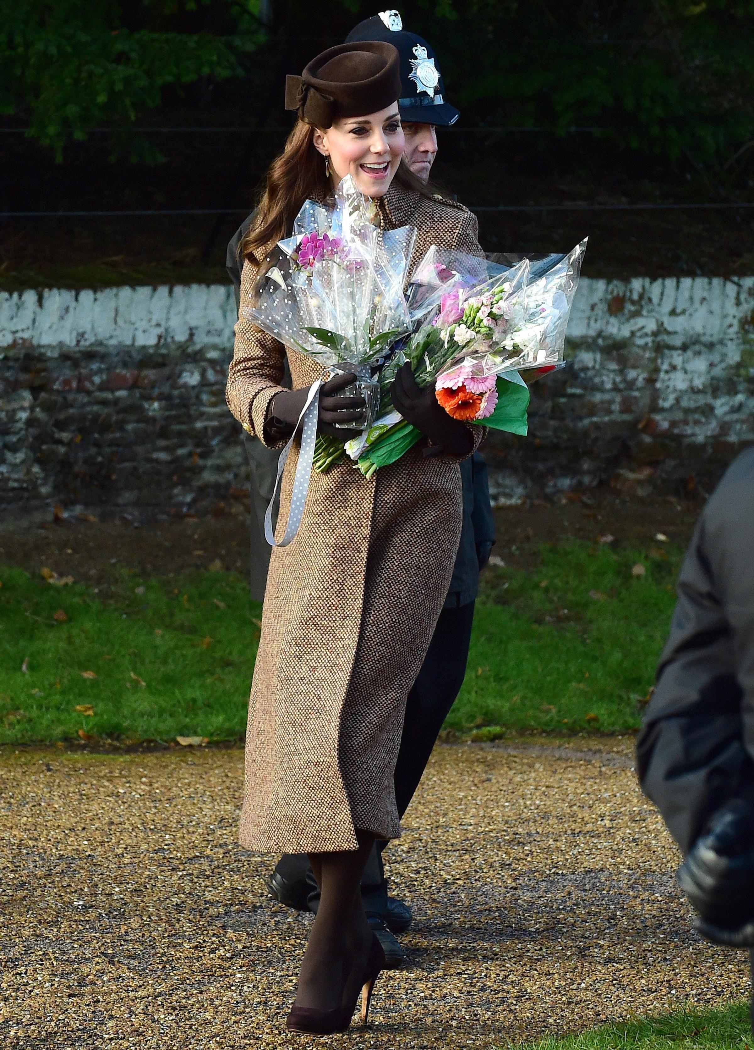 Britain's Catherine, Duchess of Cambridge, receives flowers from well-wishers after attending with other members of the royal family the traditional Christmas Day Church Service at Sandringham in eastern England, on Dec. 25, 2014.