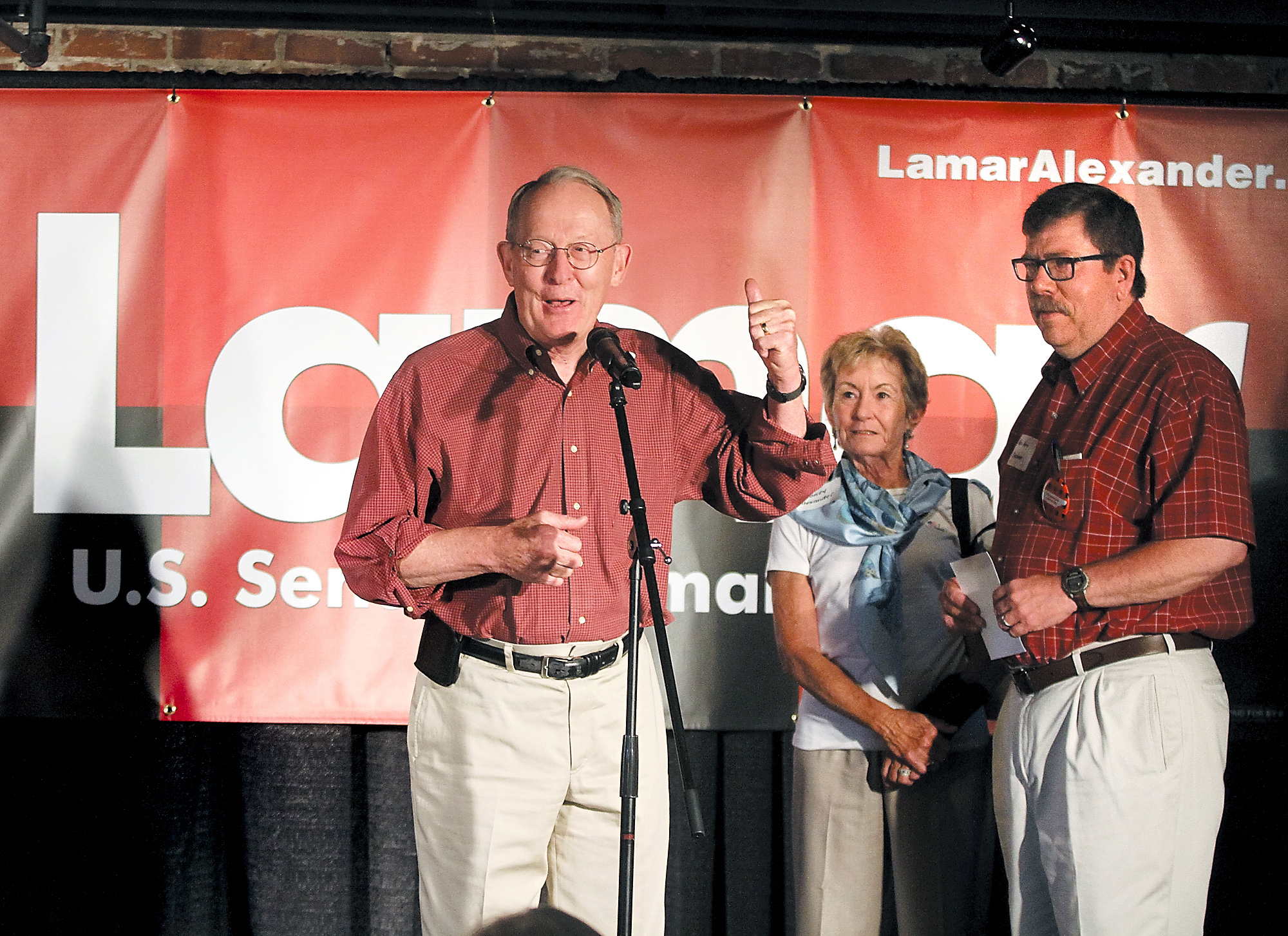 U.S. Senator Lamar Alexander announces the kickoff of his "Standing Up for Tennessee" bus tour at Sullivan's Restaurant in his hometown of Maryville, Tenn., as his wife Honey and State Rep. Art Swann look on on July 25, 2014.