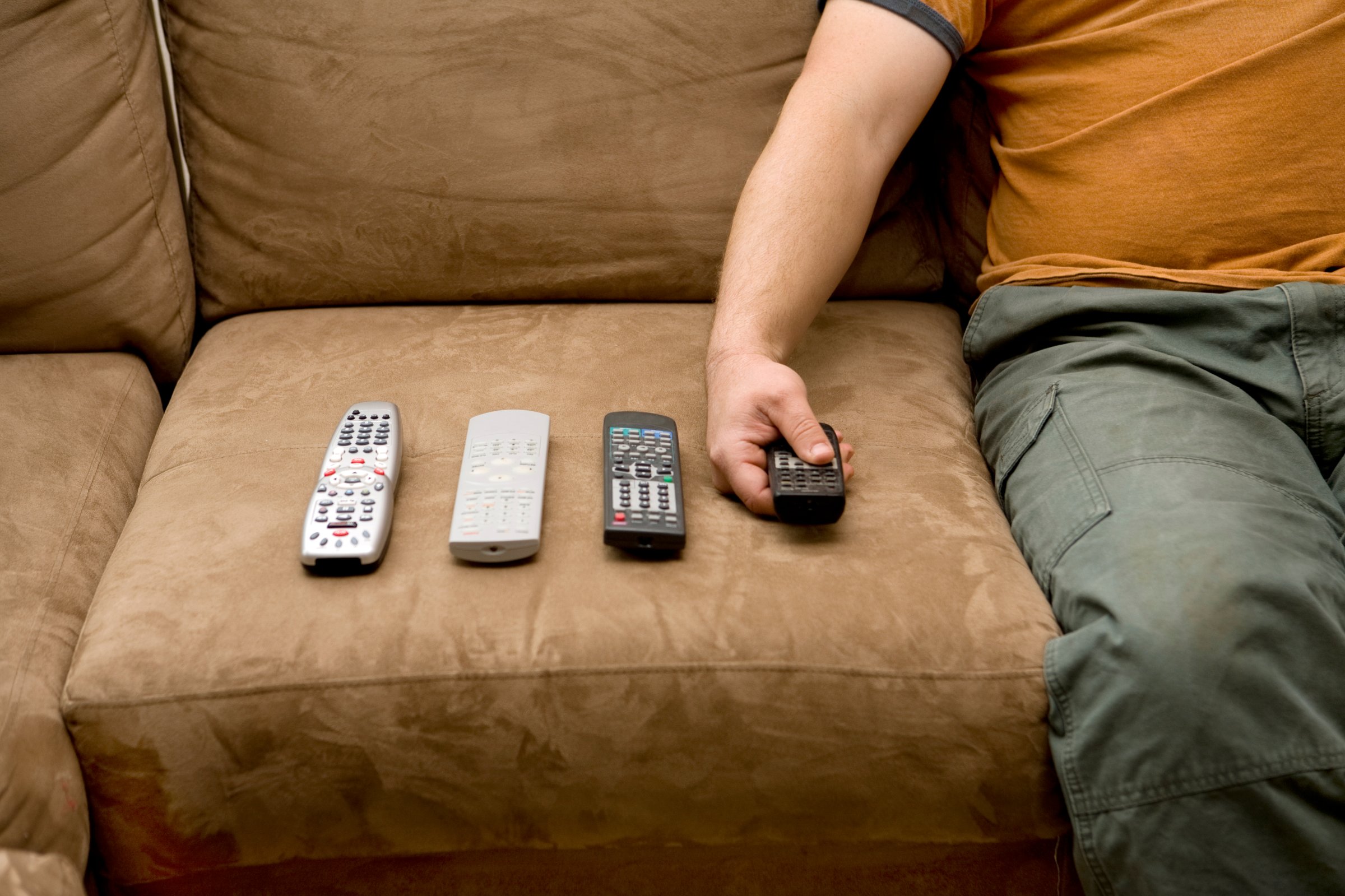 Overweight man using remote controls