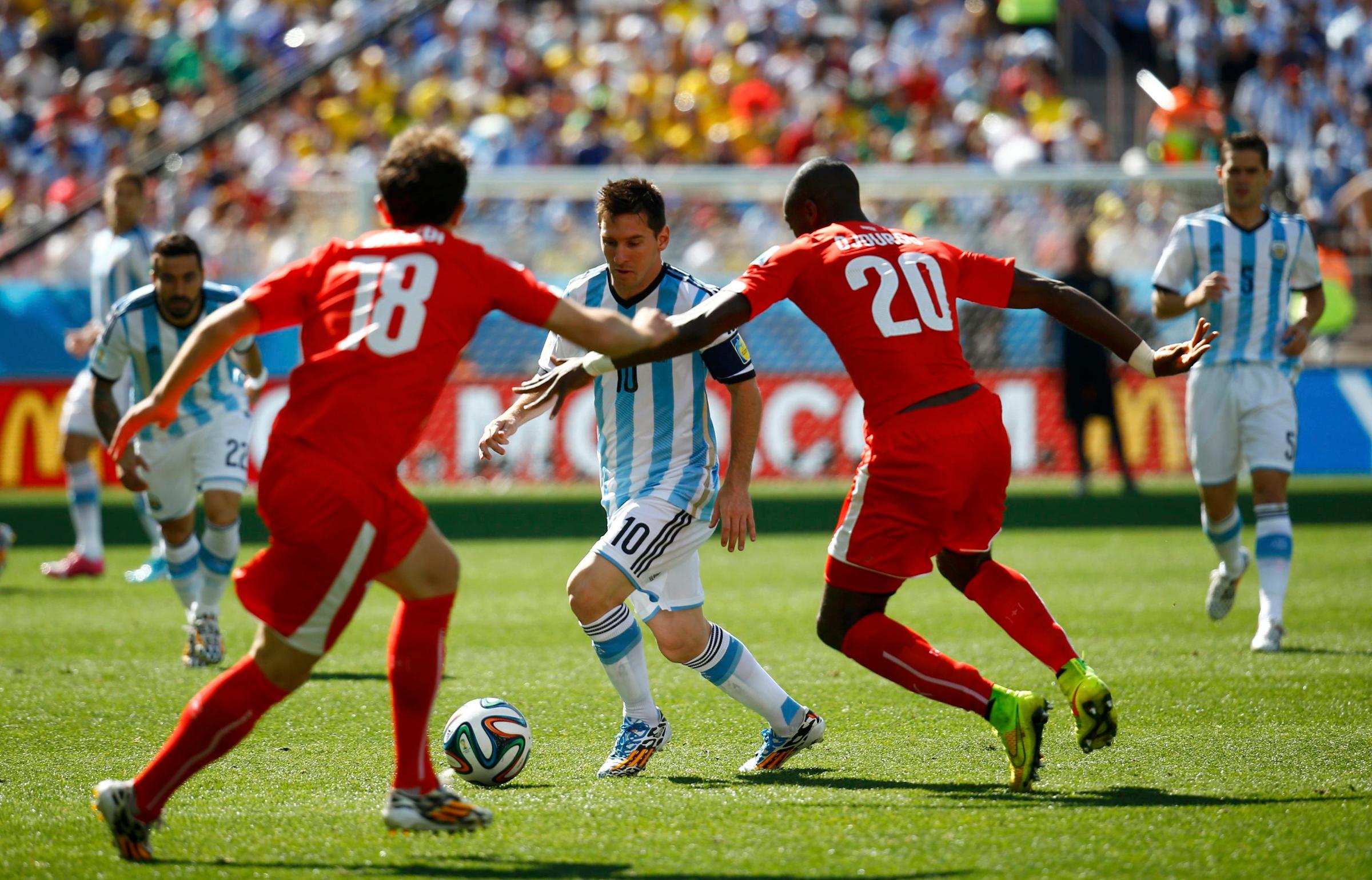 Argentina's Messi fights for the ball with Switzerland's Mehmedi and Djourou during their 2014 World Cup round of 16 game at the Corinthians arena in Sao Paulo