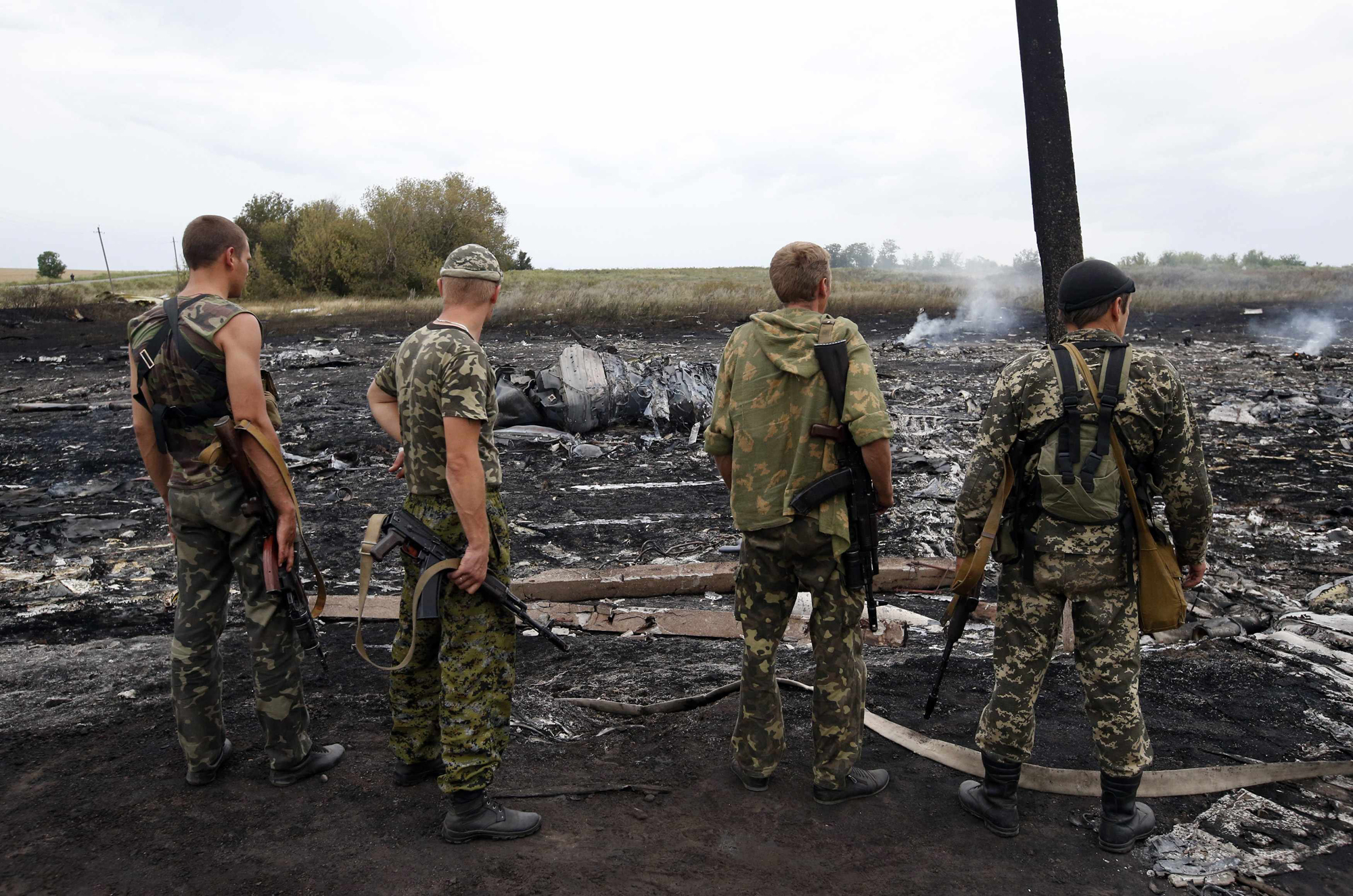 Armed pro-Russian separatists stand at the site of a Malaysia Airlines Boeing 777 plane crash near the settlement of Grabovo in the Donetsk region, July 17, 2014.