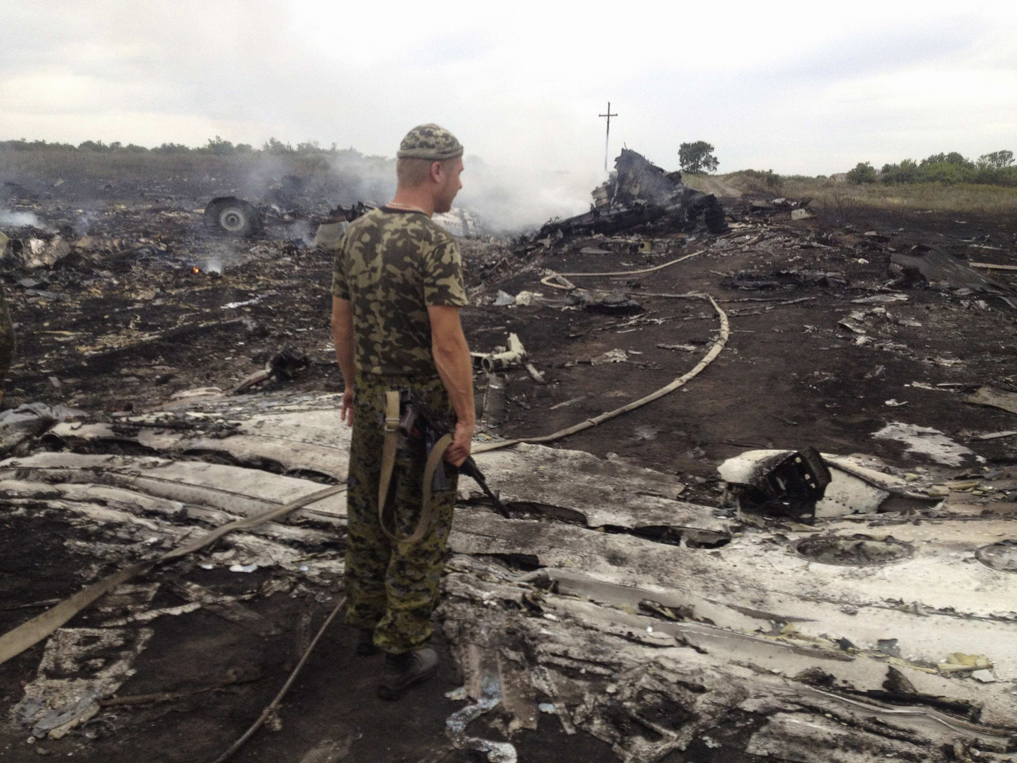 An armed pro-Russian separatist stands at a site of a Malaysia Airlines Boeing 777 plane crash in the settlement of Grabovo in the Donetsk region, July 17, 2014.