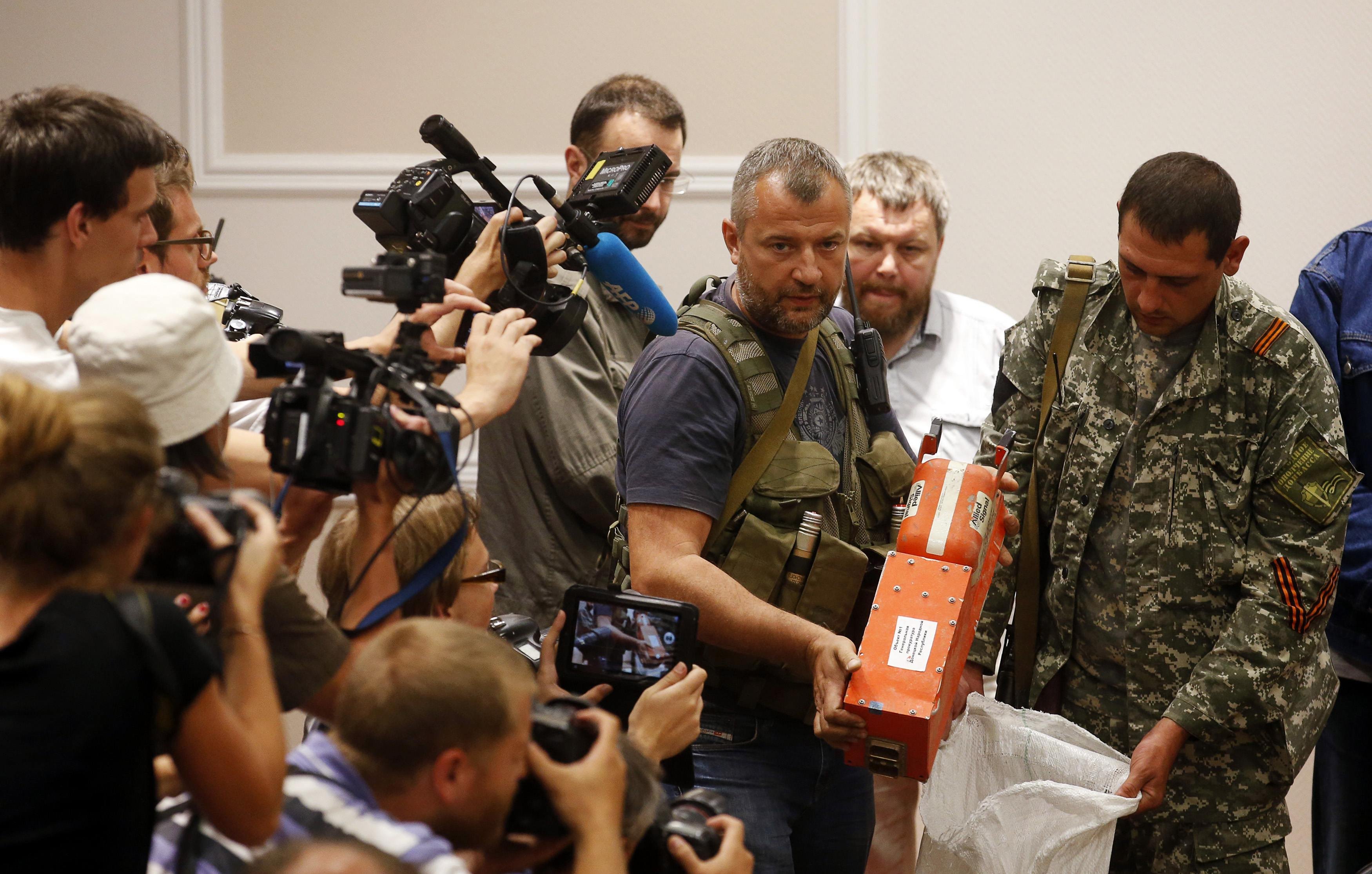 A pro-Russian separatist shows members of the media a black box belonging to Malaysia Airlines flight MH17, before its handover to Malaysian representatives, in Donetsk on July 22, 2014. (Maxim Zmeyev—Reuters)