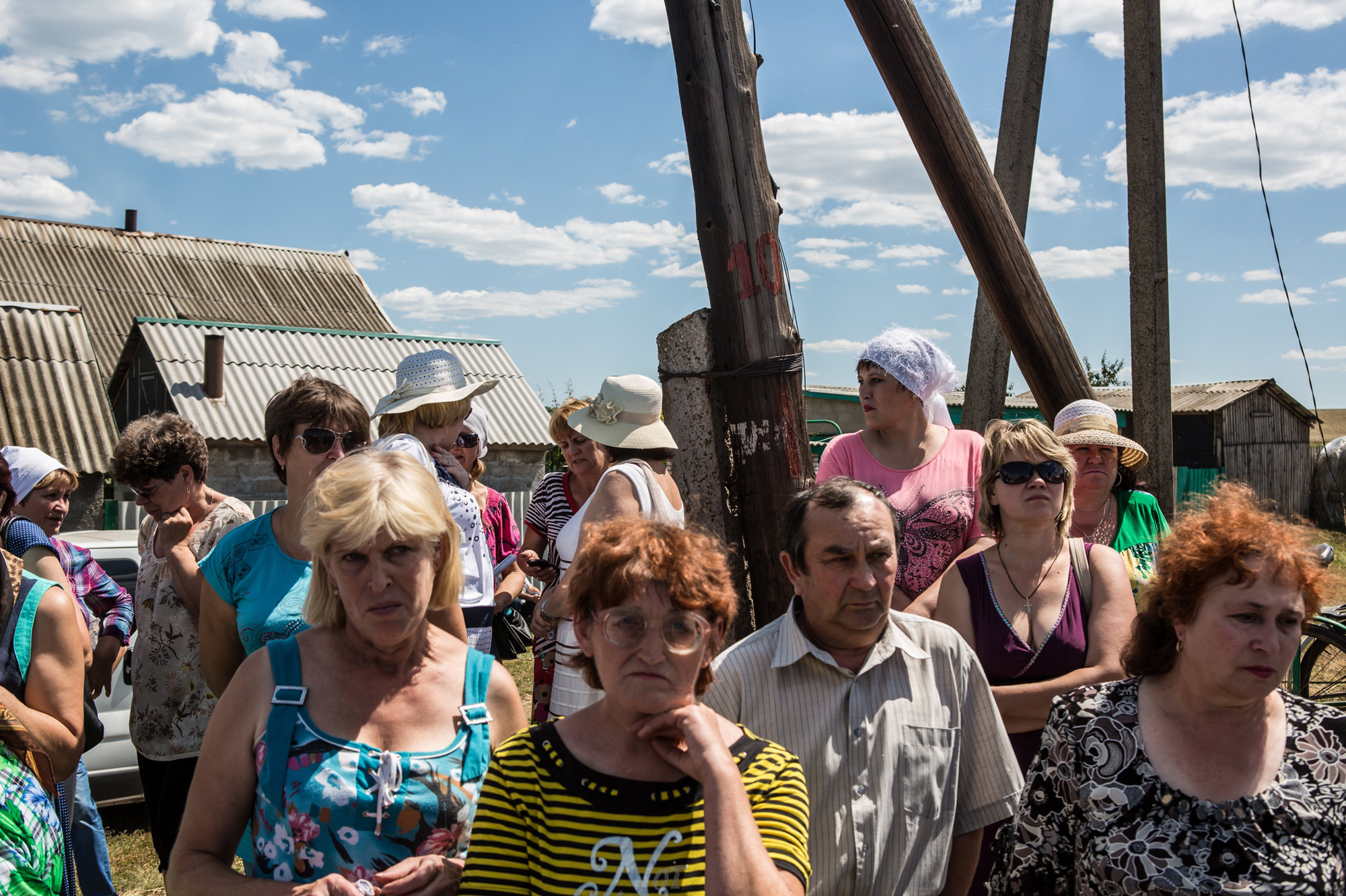 Local residents gather to watch as the bodies of victims of Malaysia Airlines Flight 17 are removed from the scene of the crash on July 21, 2014 in Grabovo, Ukraine.