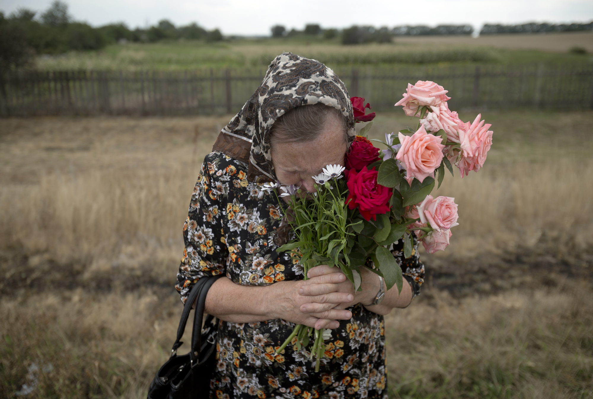 A woman cries during a religious service held by villagers in memory of the victims at the crash site of Malaysia Airlines Flight 17, near the village of Hrabove, eastern Ukraine, July 22, 2014.