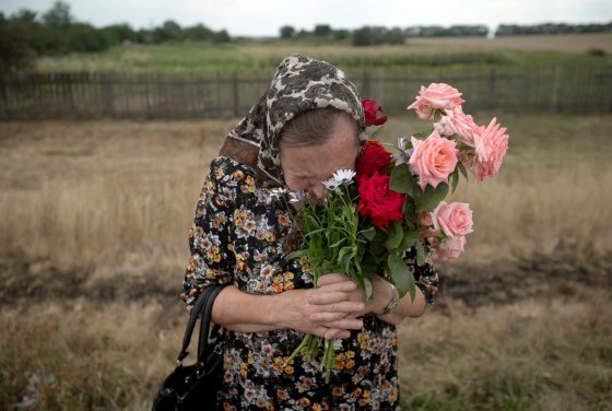 A woman cries during a religious service held by villagers in memory of the victims at the crash site of Malaysia Airlines Flight 17, near the village of Hrabove, eastern Ukraine, July 22, 2014.