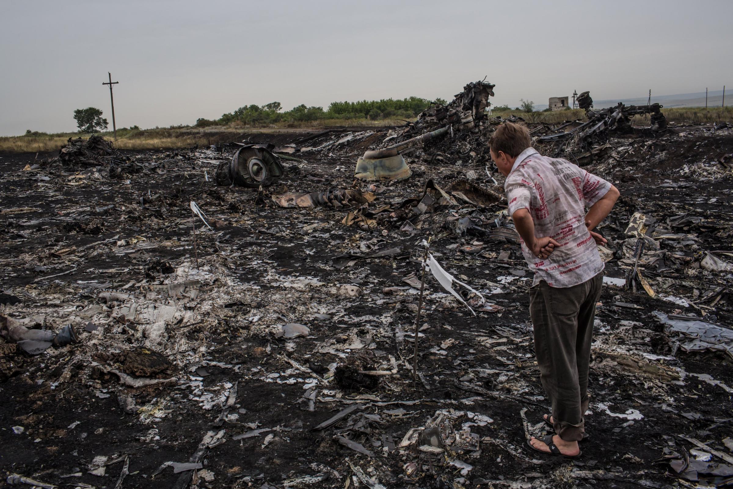 A man looks at debris from an Air Malaysia plane crash on July 18, 2014 in Grabovka, Ukraine.